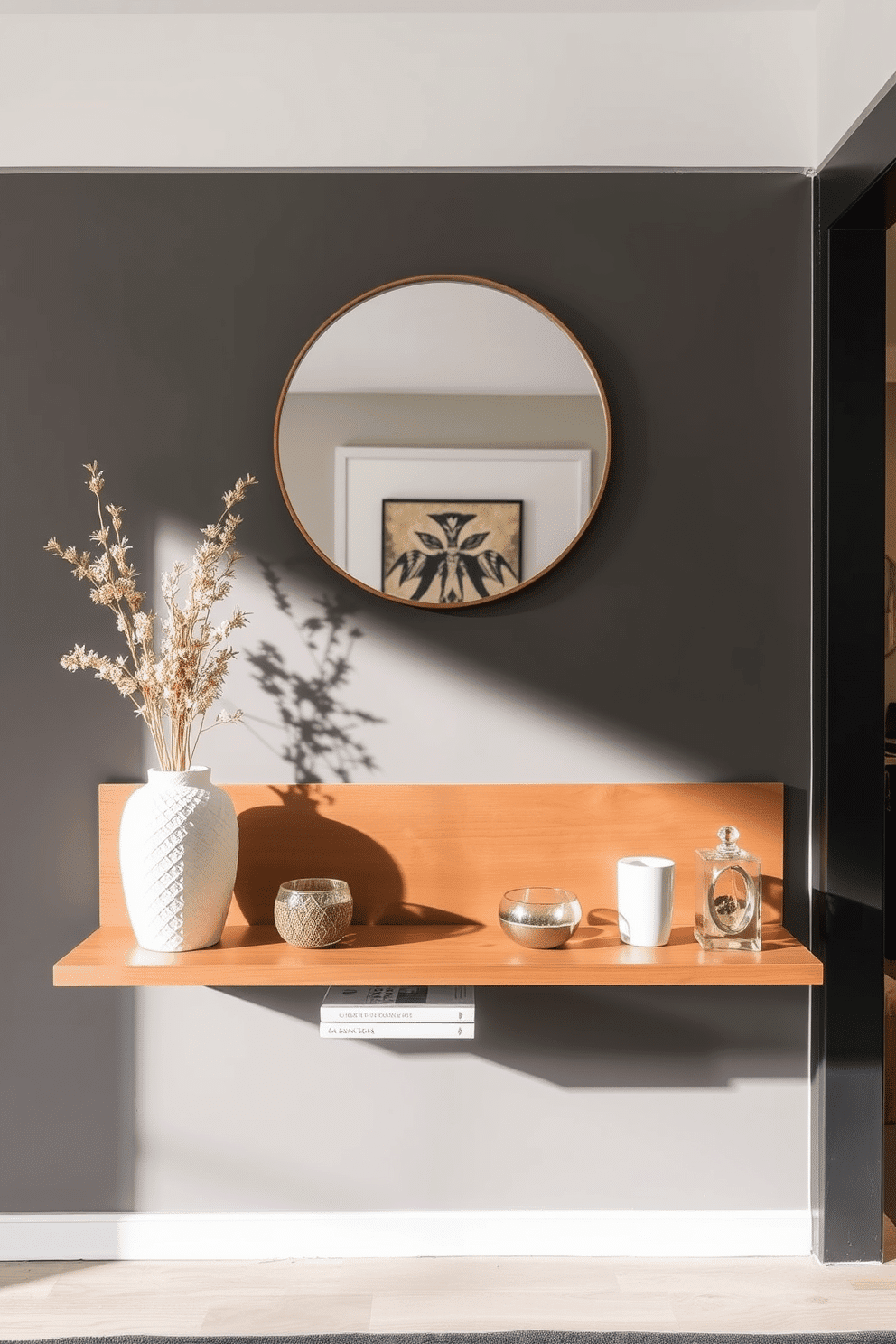 A stylish apartment entryway features a sleek floating shelf adorned with carefully curated decorative items. Above the shelf, a round mirror with a minimalist frame reflects natural light, creating an inviting ambiance.