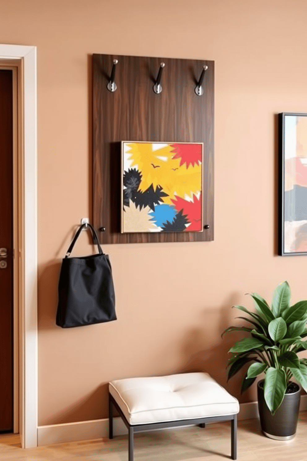 A stylish apartment entryway features a wall-mounted coat rack made of sleek, dark wood, providing an elegant yet functional touch. Below the rack, a small, minimalist bench with a soft cushion invites guests to sit while removing their shoes, enhancing the welcoming atmosphere. The walls are painted in a warm neutral tone, complemented by a vibrant piece of abstract art that adds a splash of color. A decorative potted plant sits in the corner, bringing a touch of nature indoors and creating a fresh, inviting entryway.