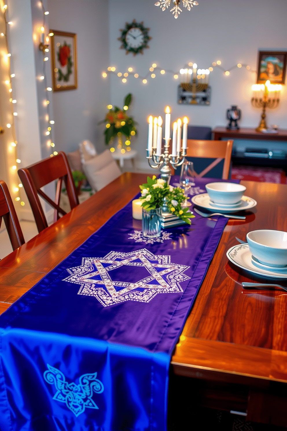 A beautifully set dining table features a vibrant table runner adorned with an intricate Star of David design, crafted from rich blue and silver fabrics. The runner stretches across a polished wooden table, complemented by elegant white dinnerware and shimmering silver cutlery, creating a festive atmosphere for Hanukkah celebrations. In the background, twinkling string lights and menorah centerpieces add warmth and charm to the apartment's decor. Soft, ambient lighting enhances the cozy feel, inviting guests to gather and celebrate the holiday spirit.