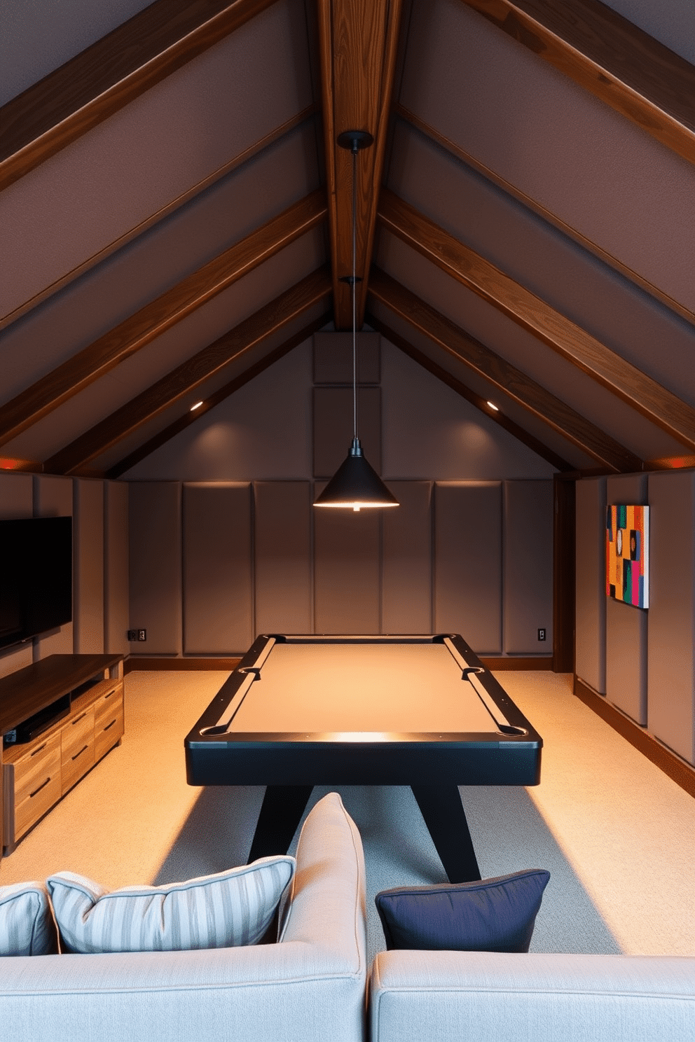 A modern attic game room with soundproofing panels on the walls to ensure a quiet environment. The space features a plush sectional sofa, a large flat-screen TV mounted on the wall, and a stylish pool table in the center, illuminated by pendant lights. The soundproofing panels are designed in a sleek, contemporary style, blending seamlessly with the room's decor. Rich wooden beams accentuate the sloped ceiling, while colorful artwork adds a playful touch to the overall ambiance.