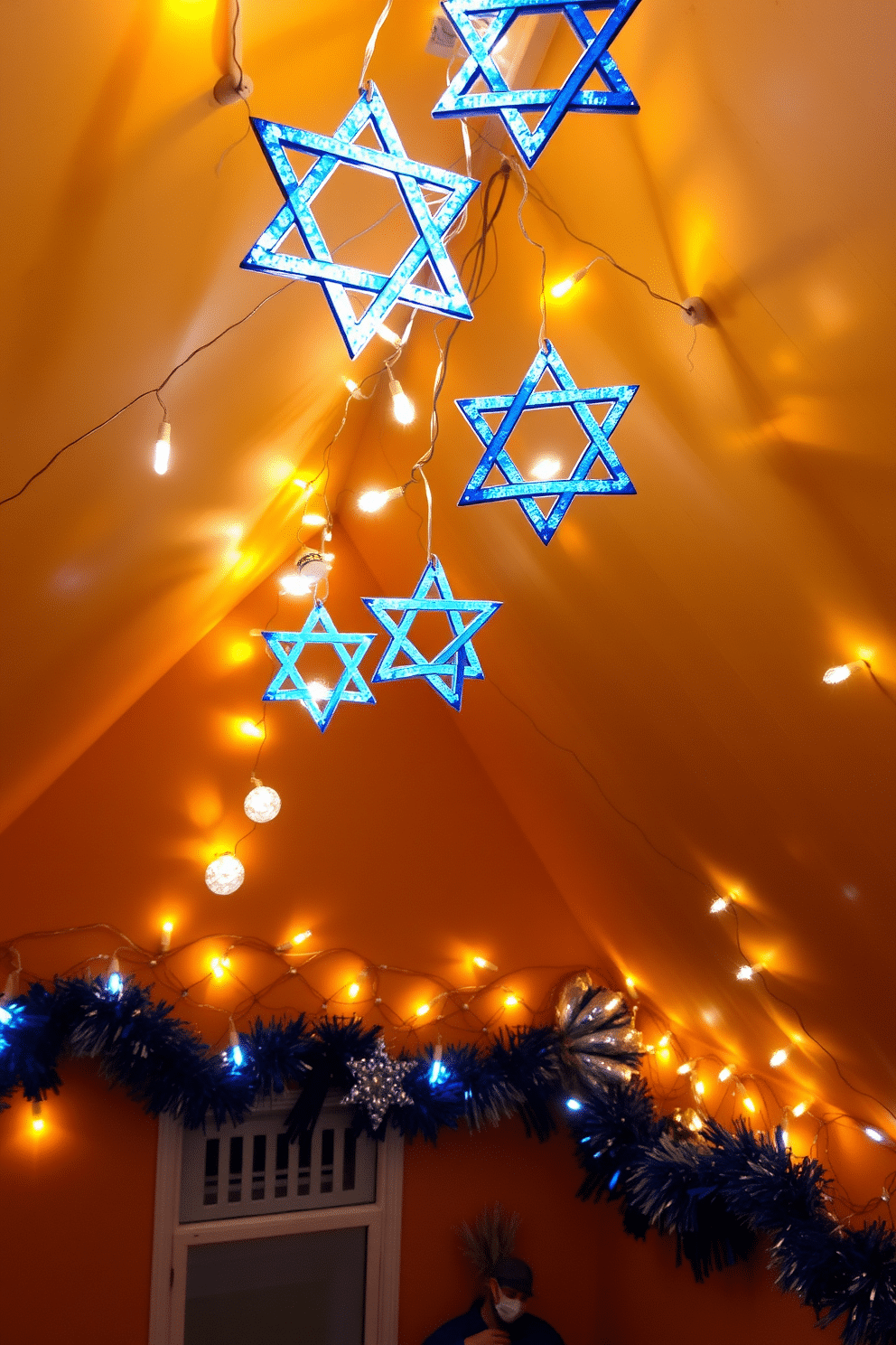 A cozy attic space adorned with Star of David string lights, casting a warm glow throughout the room. The walls are decorated with festive blue and silver ornaments, creating a cheerful atmosphere for Hanukkah celebrations.