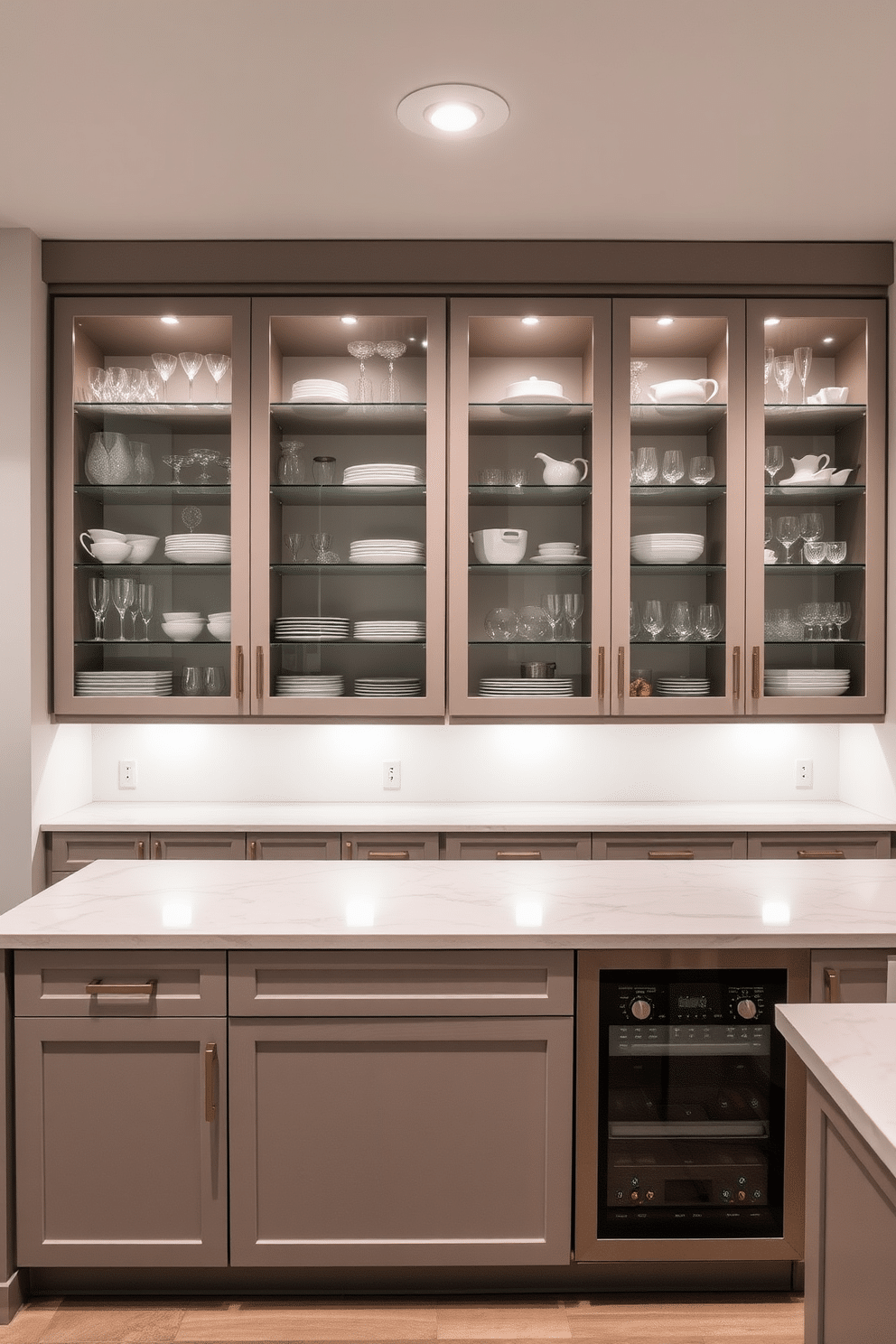 A modern basement kitchen featuring sleek glass-front cabinets that showcase an array of stylish dishware and glassware. The cabinetry is complemented by a spacious island with a marble countertop, ideal for meal prep and casual dining. The walls are painted in a light gray, creating a bright and airy atmosphere, while the floor is finished with polished concrete for a contemporary touch. Ambient lighting under the cabinets enhances the display options, making the kitchen both functional and visually appealing.