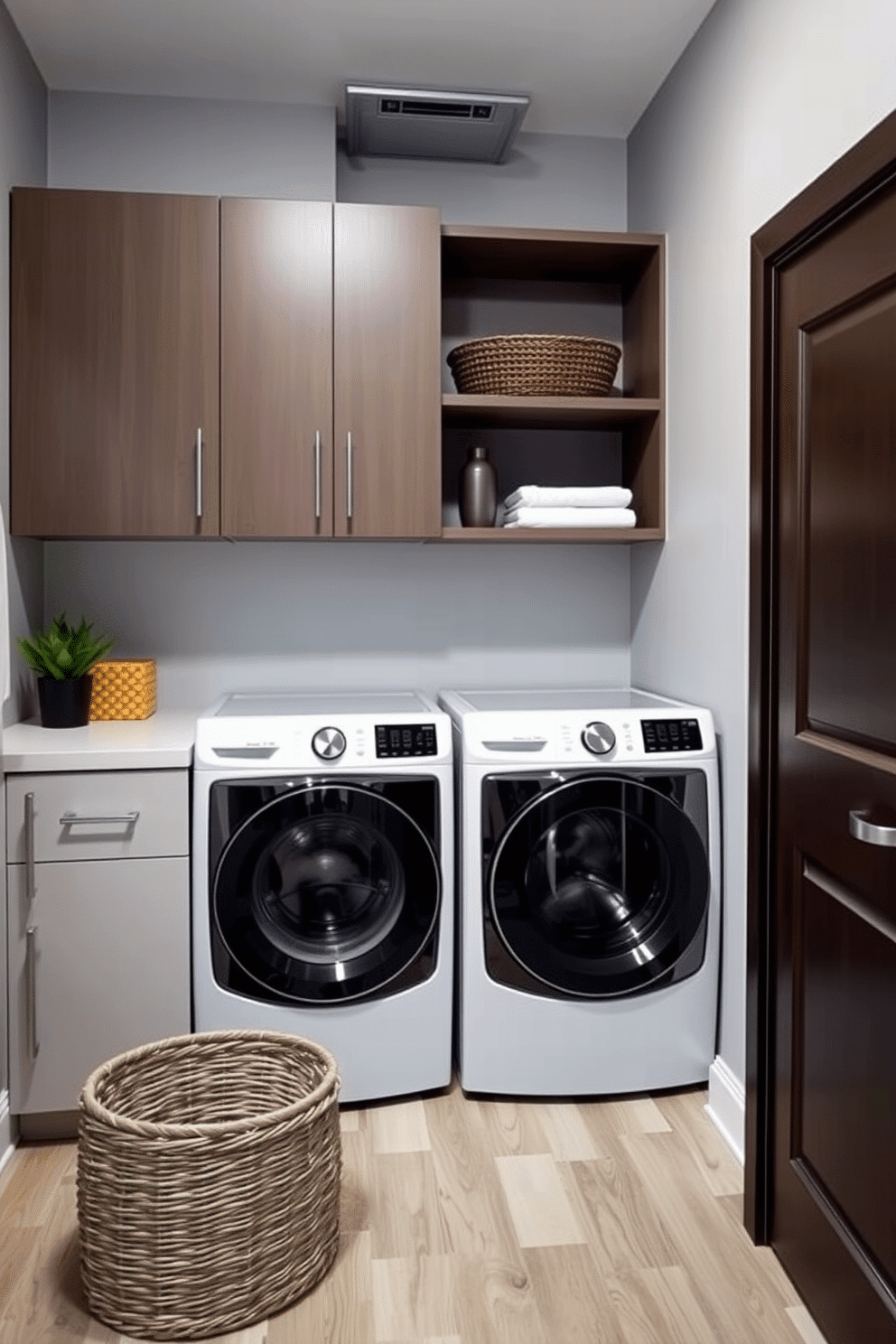 A stylish laundry room that incorporates a functional laundry chute for convenience. The space features a combination of sleek cabinetry and open shelving, allowing for both storage and display of decorative items. The walls are painted in a soft gray, complemented by a bright white countertop where a modern washer and dryer are seamlessly integrated. A large basket sits in the corner, while a small potted plant adds a touch of greenery to the room.