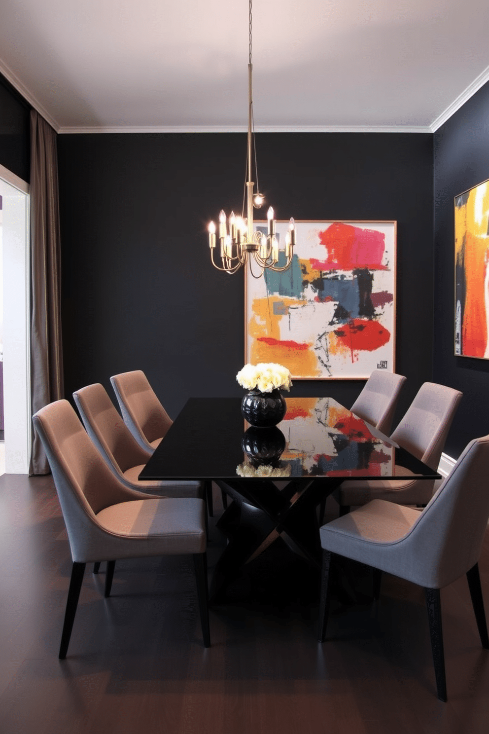 A sleek black dining table with a glass top is the centerpiece of the room, surrounded by modern, high-back chairs upholstered in a soft gray fabric. The walls are painted in a deep charcoal color, creating a dramatic backdrop that enhances the elegance of the space. Soft, ambient lighting is provided by a contemporary chandelier that hangs above the table, casting a warm glow over the setting. A large piece of abstract art in vibrant colors adorns one wall, adding a touch of personality and contrast to the sophisticated atmosphere.