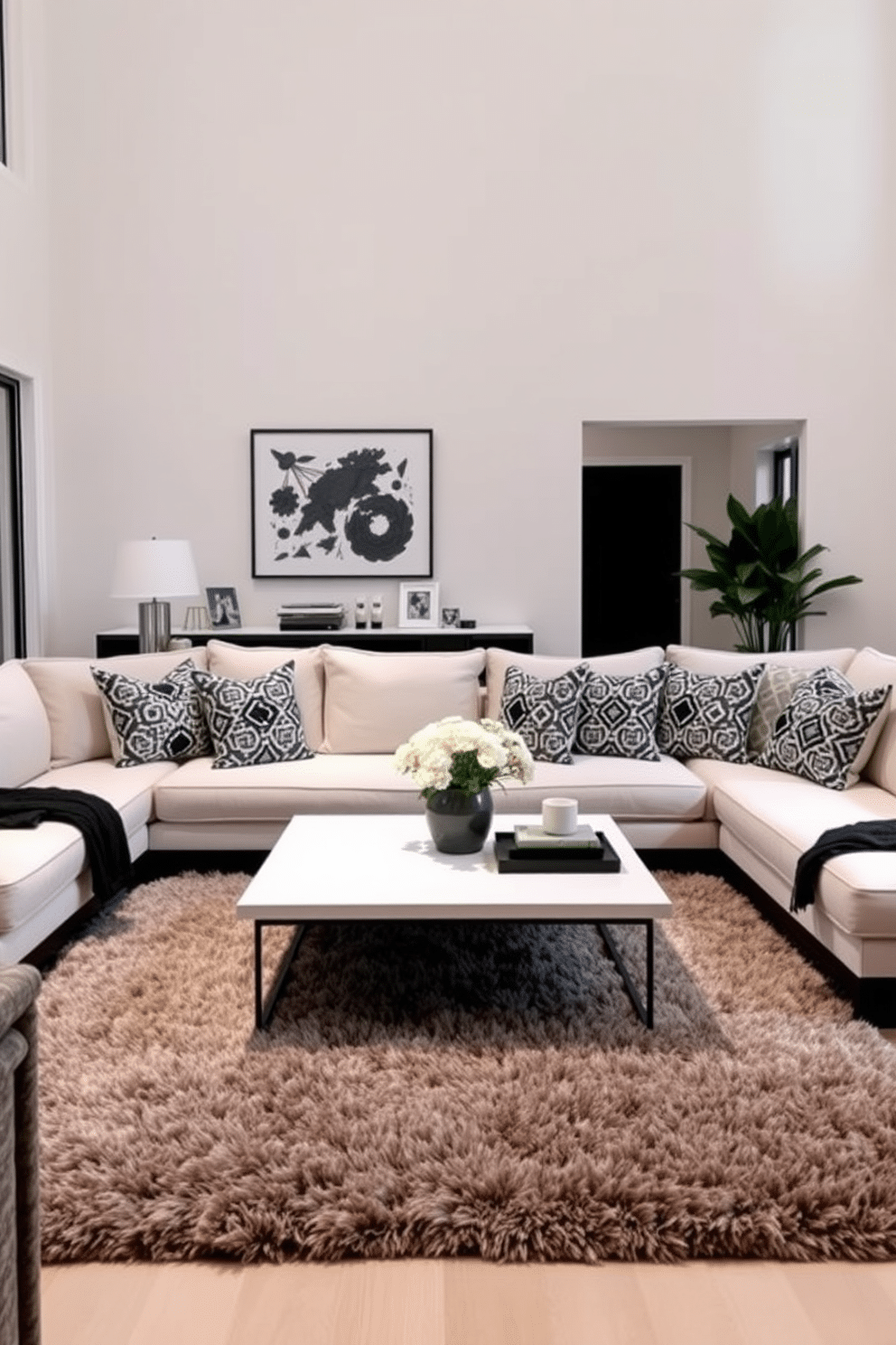 A stylish family room featuring a cozy sectional sofa adorned with black and gray geometric patterned cushions. The walls are painted in a soft white, creating a bright and airy atmosphere, while a sleek coffee table sits in the center, complemented by a plush area rug that adds warmth to the space.