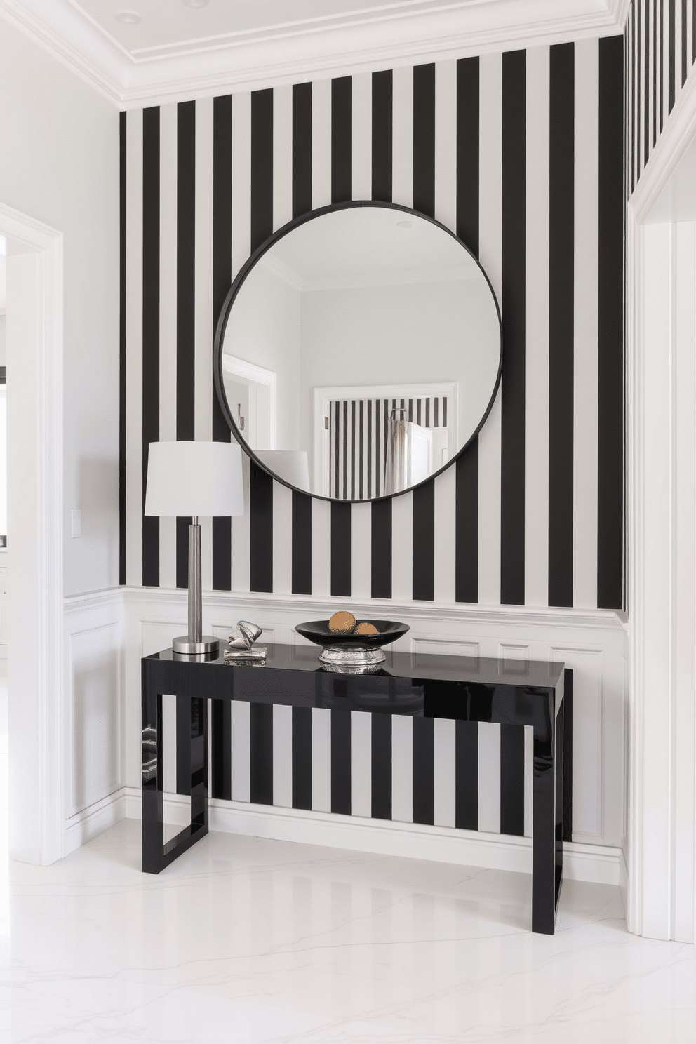 A striking foyer features dramatic black and white striped wallpaper that creates an eye-catching backdrop. A sleek console table in a glossy black finish stands against the wall, adorned with a stylish lamp and a decorative bowl. The flooring is a polished white marble, contrasting beautifully with the bold wallpaper. A large round mirror with a thin black frame hangs above the console, reflecting the elegance of the space.