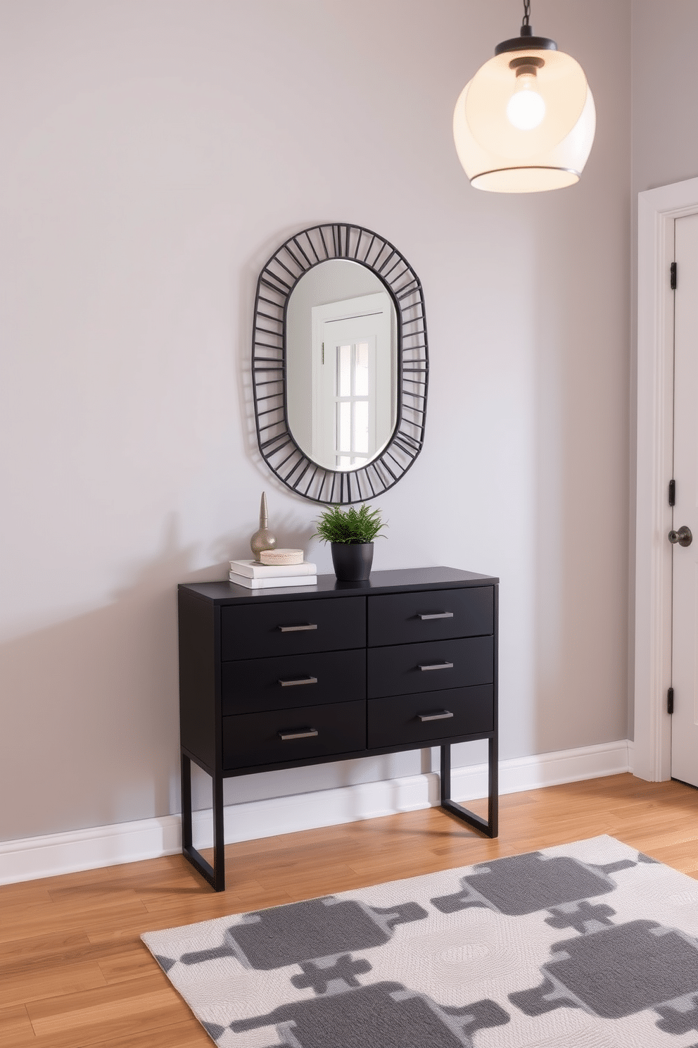 A stylish black entryway table with sleek drawers stands against a backdrop of soft gray walls. The table is adorned with a decorative mirror above it, creating a sense of depth, while a small potted plant adds a touch of greenery to the space. The foyer features a chic runner rug in a geometric pattern, complementing the table's modern aesthetic. Ambient lighting from a pendant fixture casts a warm glow, enhancing the inviting atmosphere of the entryway.