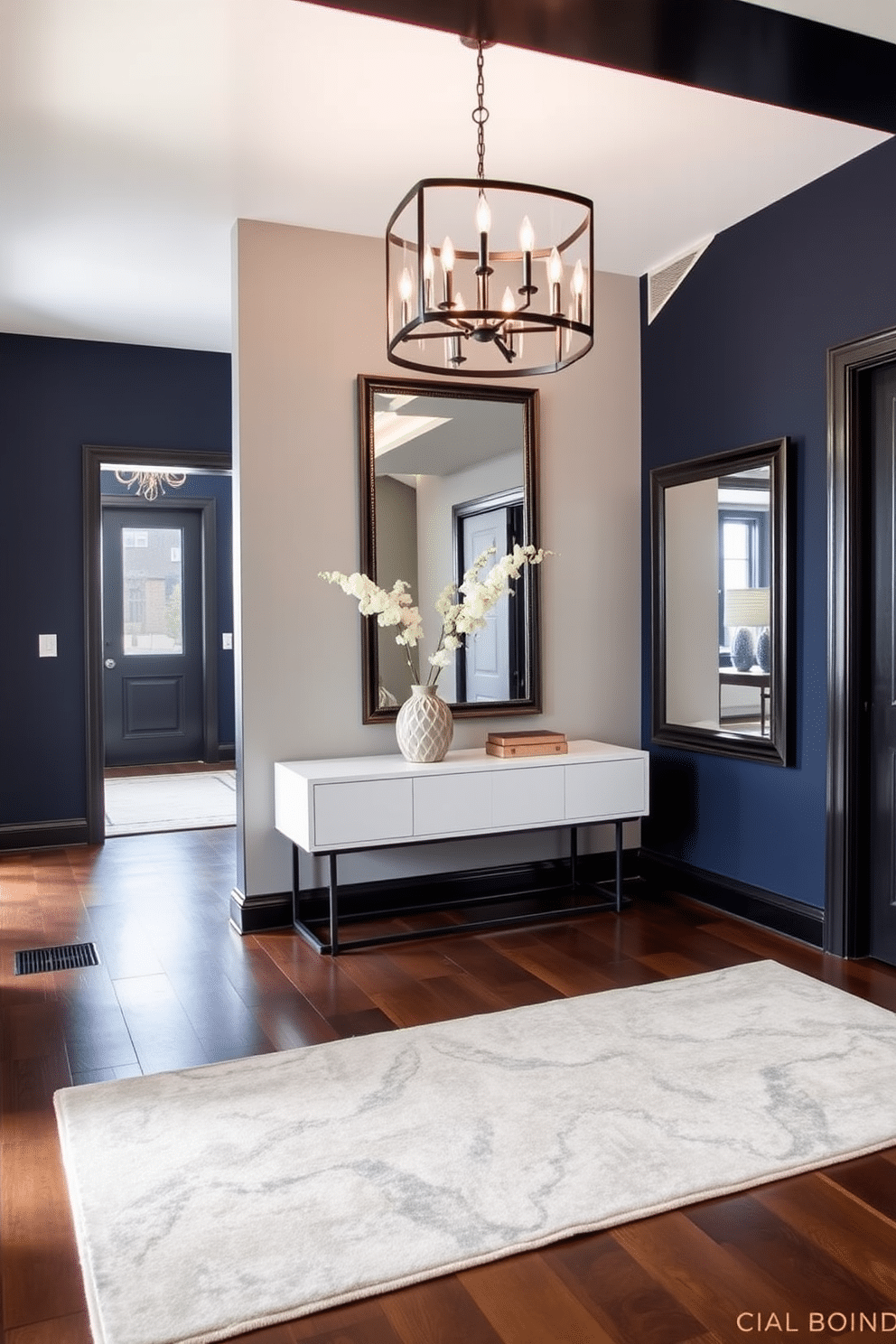 Chic black framed mirrors adorn the walls of a stylish foyer, reflecting the elegant ambiance of the space. The floor is covered in a rich, dark hardwood, complemented by a statement console table in a sleek design. The foyer features a bold accent wall painted in a deep navy blue, adding depth and sophistication. A plush area rug in muted tones anchors the space, while a modern chandelier hangs above, providing warm illumination.