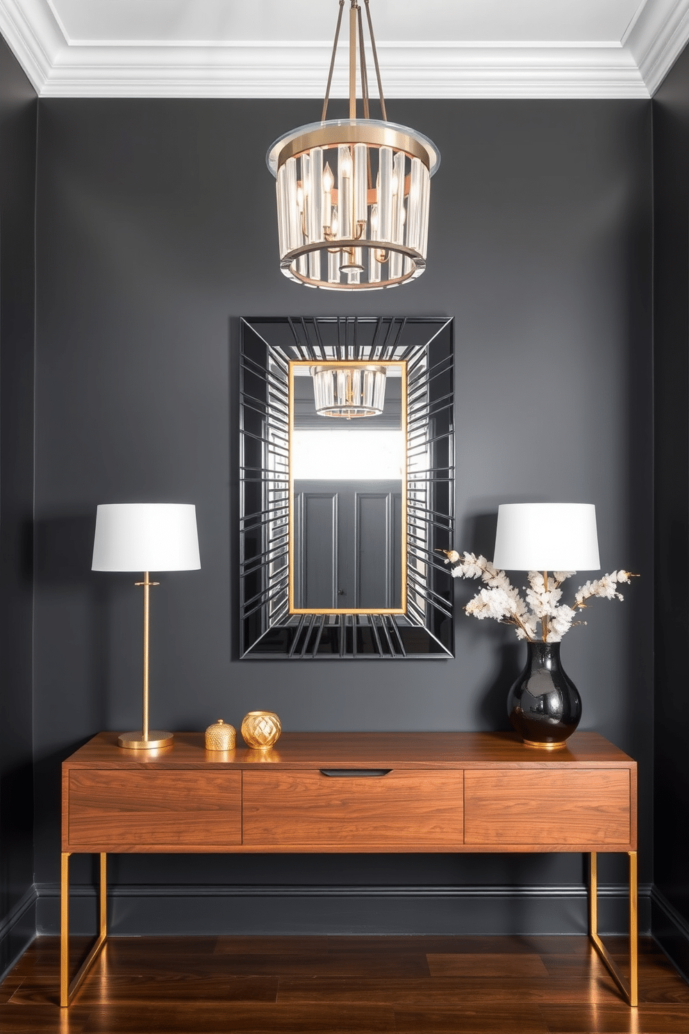 A striking foyer features a modern black and gold mirror as the centerpiece, elegantly reflecting the light from a stylish chandelier above. The walls are adorned with a deep charcoal paint, while a sleek console table in a rich walnut finish sits beneath the mirror, accented by decorative items in gold tones.