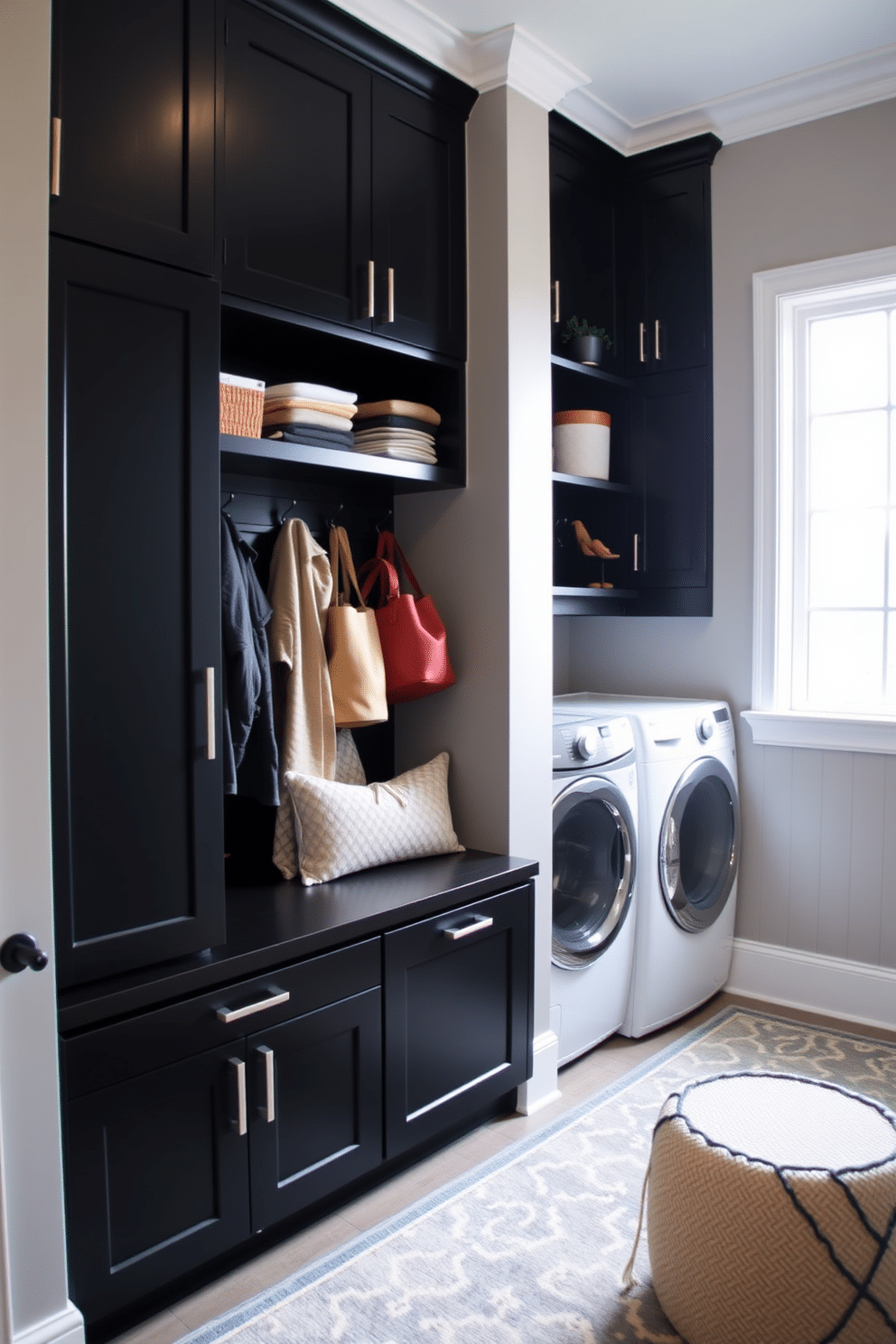 A functional mudroom-laundry combo featuring sleek black cabinetry and modern appliances. The space includes a built-in bench with storage underneath, and a stylish area rug adds warmth to the room. The walls are painted in a soft gray, providing a subtle contrast to the black elements. A large window allows natural light to flood the space, highlighting the organized shelves and decorative hooks for coats and bags.