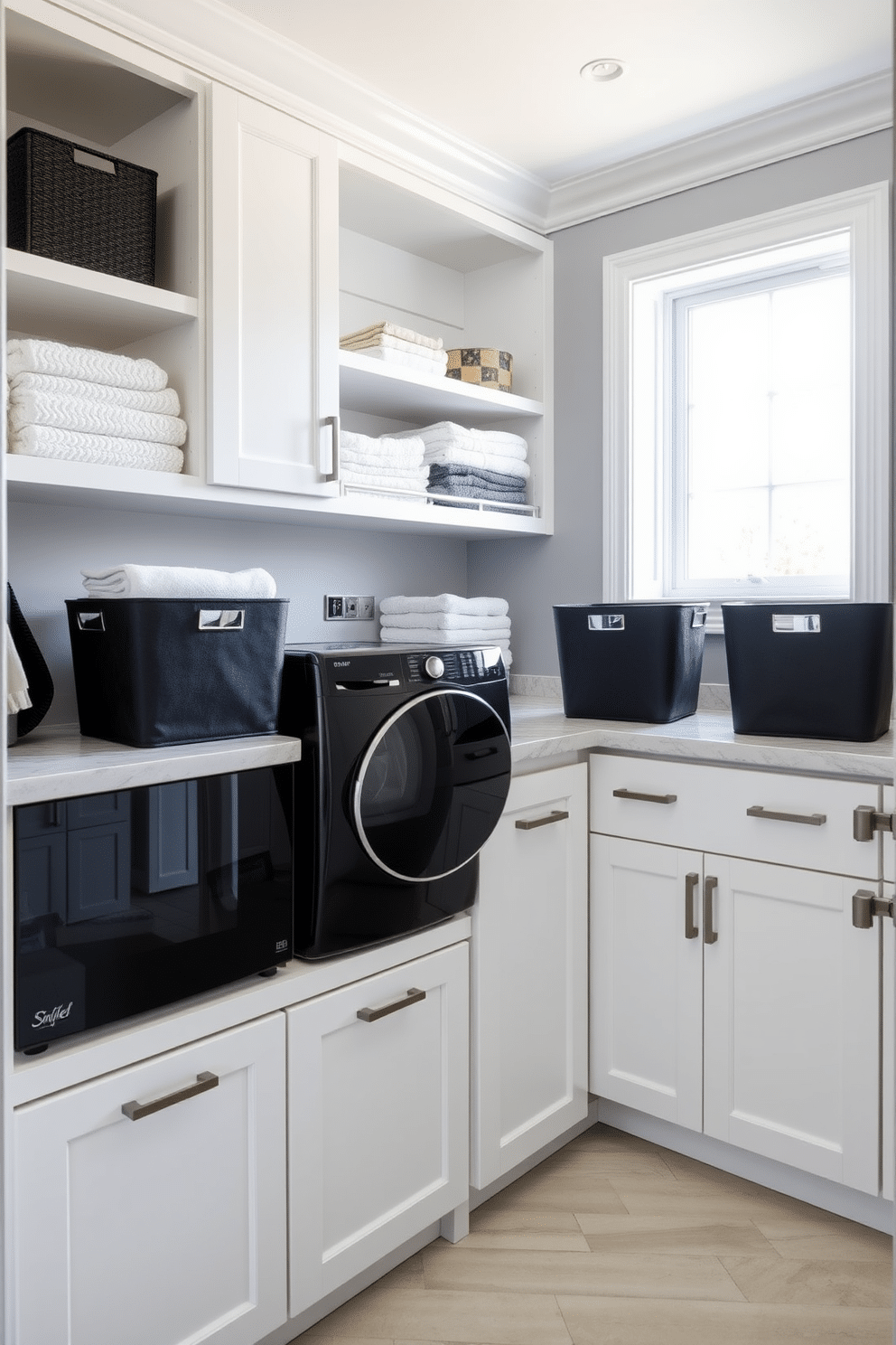 A modern laundry room featuring sleek black laundry hampers and bins that add a touch of elegance. The space is bright and airy, with white cabinetry and a marble countertop providing a clean backdrop for the stylish storage solutions. The walls are painted in a soft gray, enhancing the contrast with the black accessories. A large window allows natural light to flood the room, illuminating the organized shelves filled with neatly folded towels and laundry essentials.