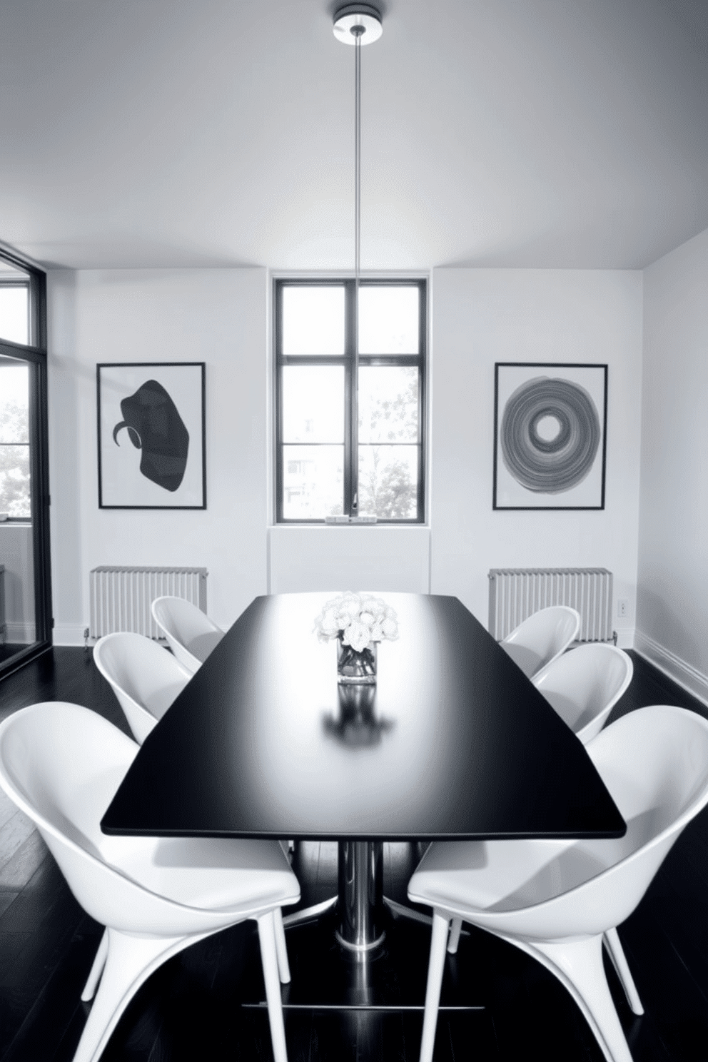 A minimalist black table is centered in the dining room, complemented by sleek white chairs that enhance the clean aesthetic. The walls are adorned with black and white artwork, creating a striking contrast that adds depth to the space. Natural light streams in through large windows, illuminating the room and highlighting the simplicity of the decor. A subtle centerpiece of white flowers sits on the table, bringing a touch of elegance to the minimalist design.