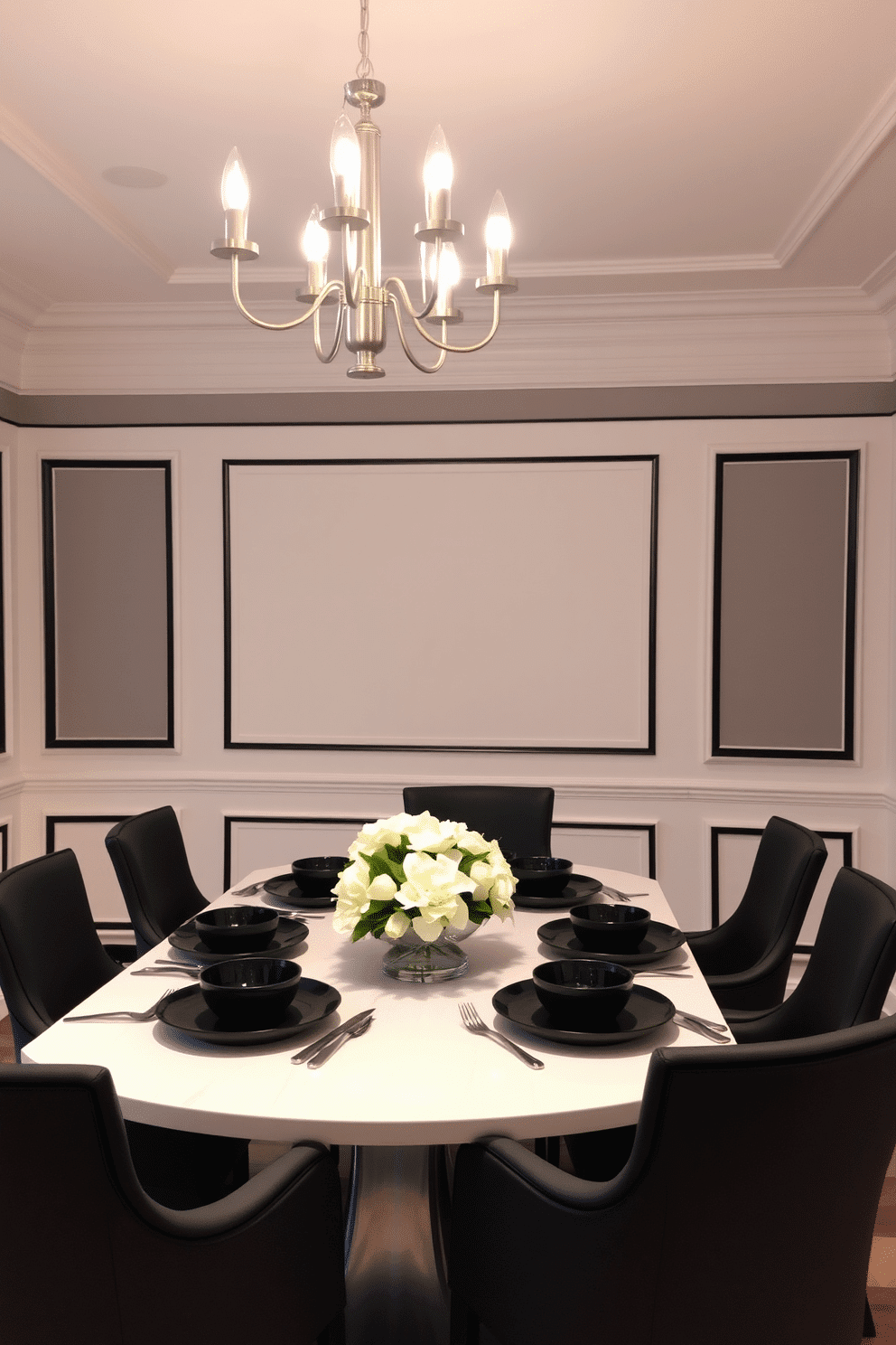 A chic dining room featuring white wainscoting adorned with sleek black trim accents. The room is illuminated by a modern chandelier, casting a warm glow over a large, rectangular dining table surrounded by elegant black upholstered chairs. The walls are painted in a soft gray, providing a subtle contrast to the crisp white and bold black elements. A decorative centerpiece of fresh white flowers sits atop the table, complemented by stylish black dinnerware and silver cutlery.