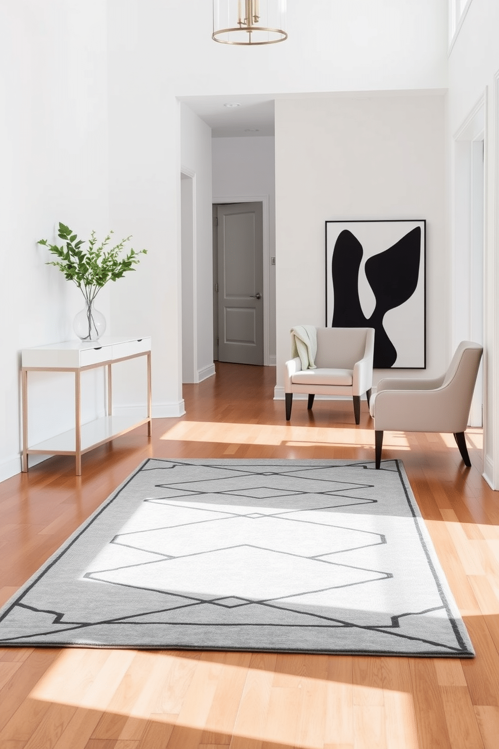 An elegant geometric rug lies at the center of a spacious foyer, complementing the minimalist decor that surrounds it. The walls are painted in a soft white, and a sleek console table with clean lines stands against one side, adorned with a simple vase of fresh greenery. In the opposite corner, a striking black and white artwork adds a bold focal point, while a pair of understated chairs in neutral tones invite guests to sit. The polished hardwood floor reflects natural light, enhancing the airy feel of the space.