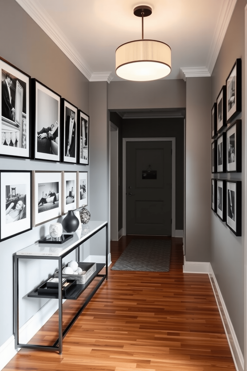 A stylish hallway adorned with framed black and white prints, creating a striking visual impact. The walls are painted in a soft gray hue, enhancing the elegance of the artwork while a sleek console table sits against one side, topped with decorative objects. The flooring features polished hardwood that adds warmth to the space, contrasting beautifully with the monochromatic theme. A contemporary pendant light hangs from the ceiling, casting a warm glow over the area and highlighting the prints.