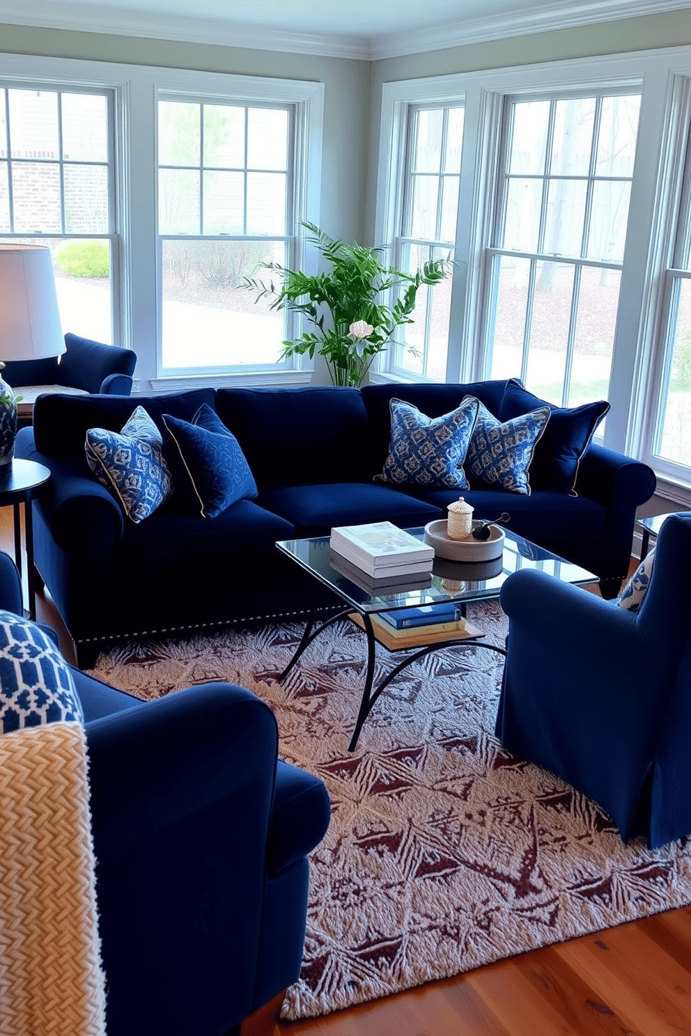 A cozy family room featuring layered blue textures, with a plush navy sofa adorned with patterned pillows in varying shades of blue. The room is accented by a soft area rug that complements the color scheme, while large windows allow natural light to flood the space, highlighting the inviting atmosphere.