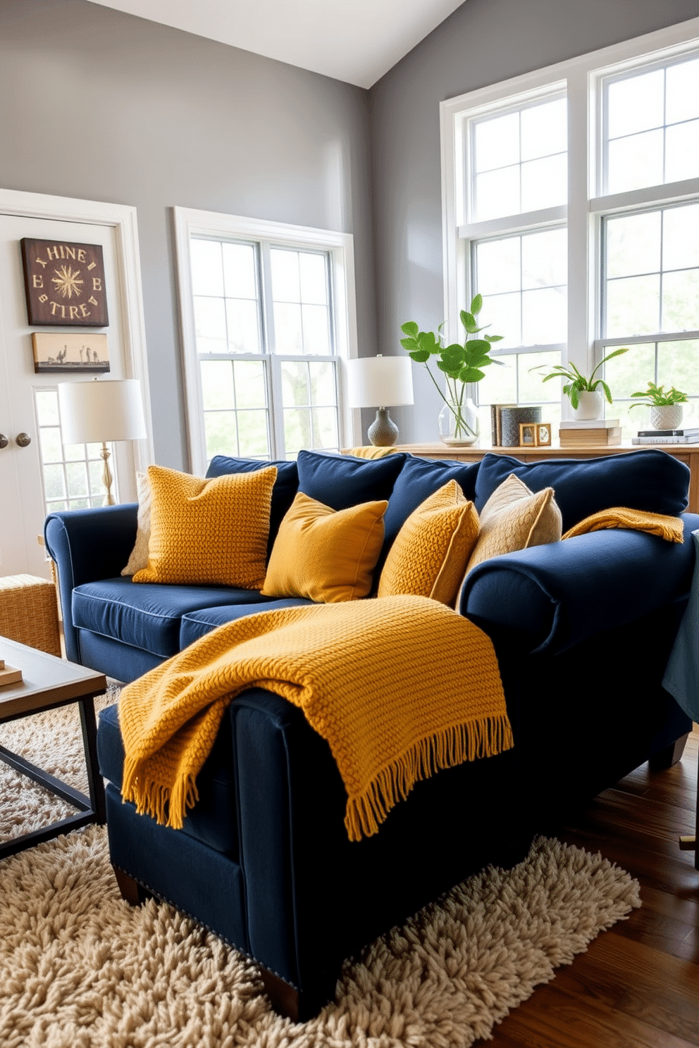 A cozy family room featuring a navy blue couch adorned with mustard yellow throws for a pop of color. The walls are painted in a soft gray, and large windows allow natural light to flood the space, highlighting a plush area rug underneath.