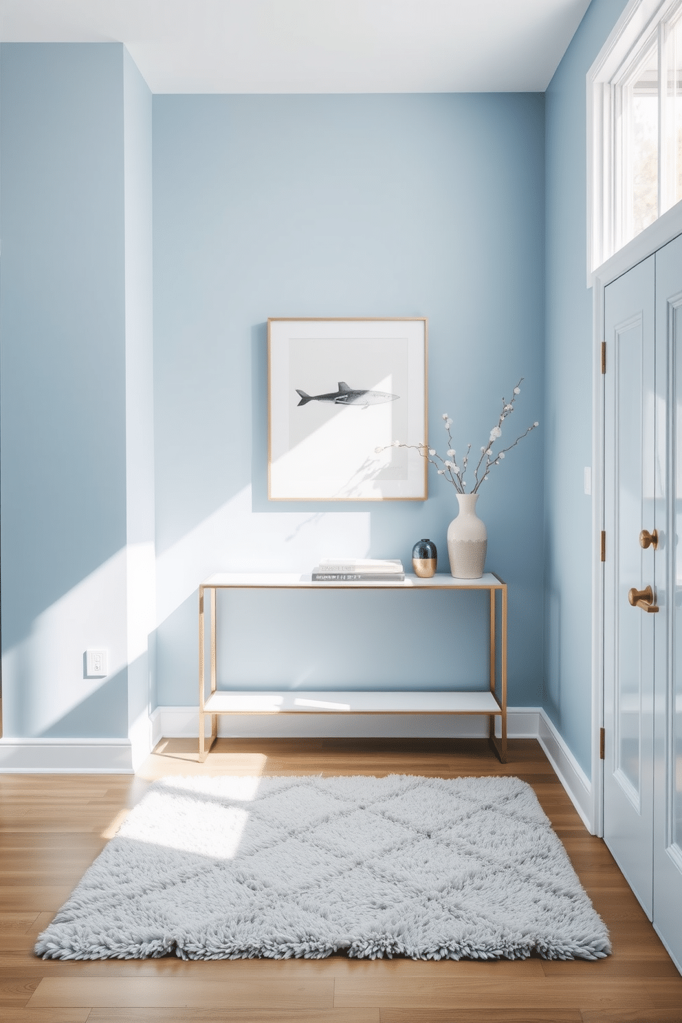 A serene foyer with ice blue walls that evoke tranquility. The space features minimalist decor, including a sleek console table and a simple abstract artwork. A plush, light gray rug lies beneath, adding warmth to the cool color palette. Natural light streams in through a large window, highlighting a few carefully selected decorative items on the table.