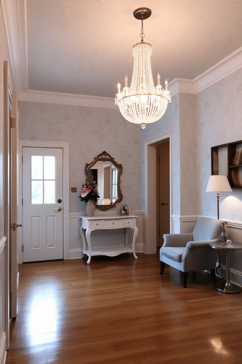 A serene foyer featuring light blue wallpaper adorned with delicate floral patterns that evoke a sense of tranquility. The space is illuminated by a crystal chandelier hanging gracefully from the ceiling, casting a warm glow over the polished hardwood floor. A stylish console table with a white finish sits against the wall, topped with a decorative mirror and a vase of fresh flowers. To the side, a cozy seating area includes a plush armchair upholstered in soft gray fabric, inviting guests to relax and enjoy the beautiful surroundings.