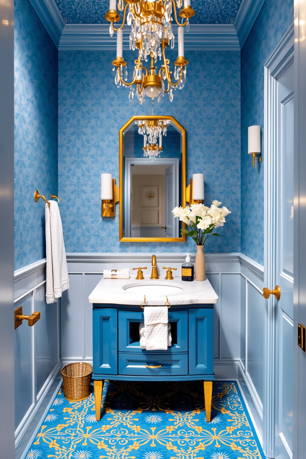 A stylish powder room featuring an elegant blue and gold color scheme. The walls are adorned with a soft blue wallpaper, while gold accents are incorporated through the fixtures and a stunning chandelier. A sleek, gold-framed mirror hangs above a chic blue vanity with a white marble countertop. The flooring consists of intricate blue and gold patterned tiles, complemented by plush towels and decorative accessories that enhance the overall luxurious feel.