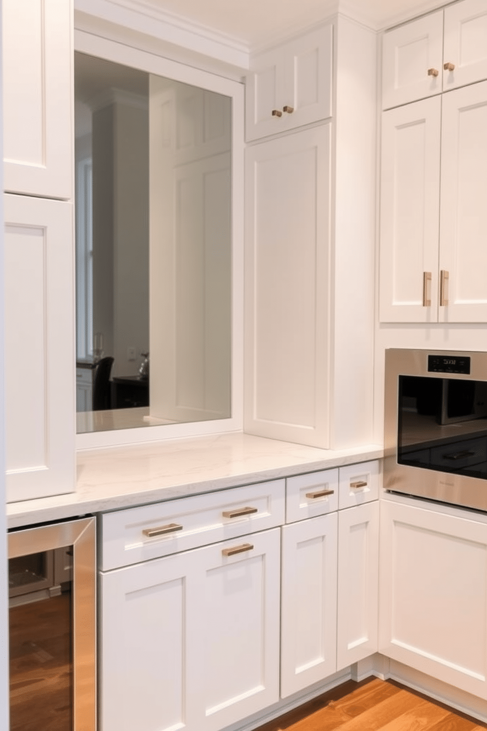 A stylish butler pantry featuring hidden appliances seamlessly integrated into custom cabinetry. The cabinetry is finished in a soft white with brushed brass hardware, creating a cohesive and elegant aesthetic. The countertop is a sleek quartz with subtle veining, providing ample space for food preparation and serving. A built-in wine cooler and a discreet microwave are tucked away behind cabinet doors, maintaining a clean and uncluttered look.