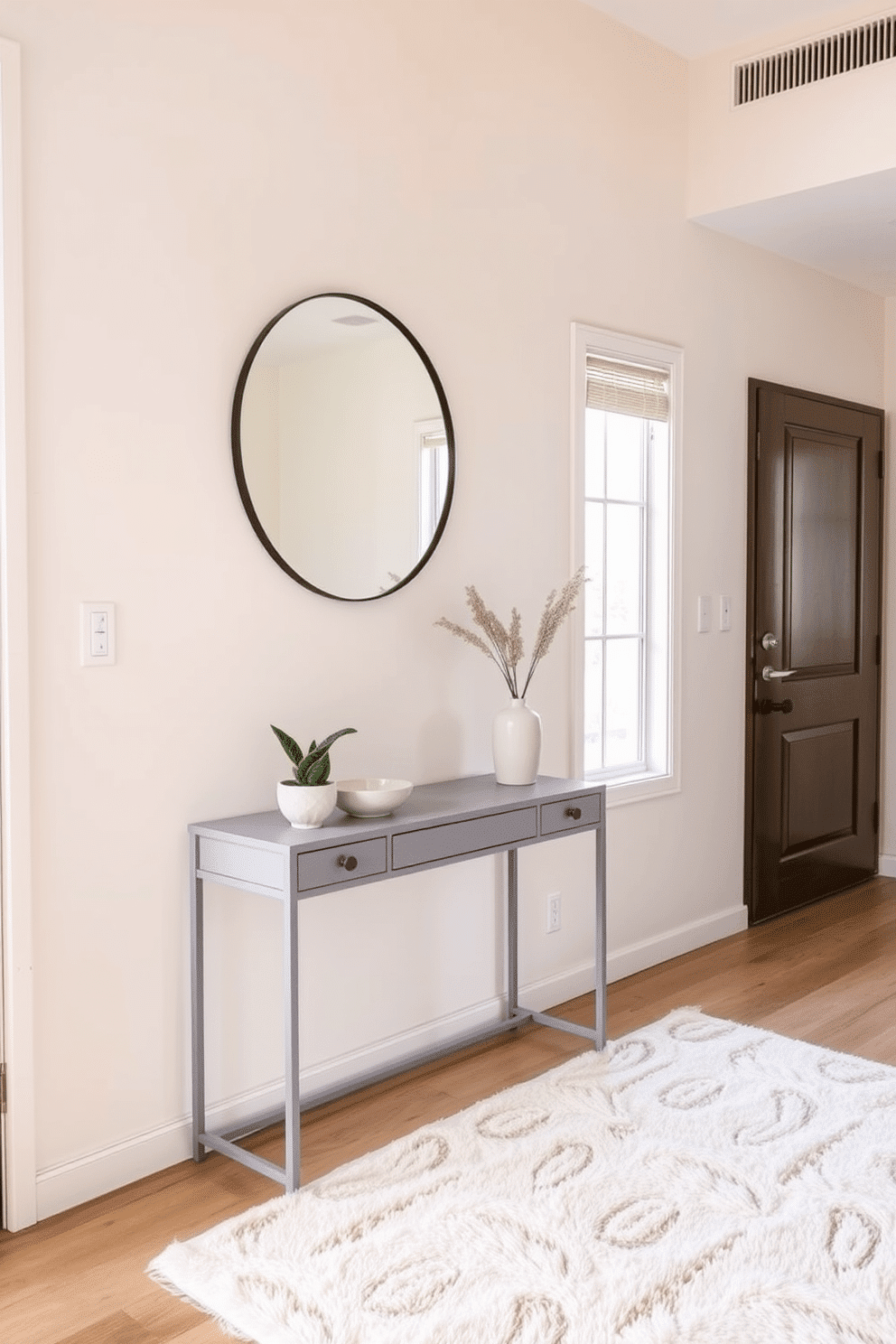 A serene condo entryway featuring a neutral color palette that promotes a calming effect. The walls are painted in soft beige, complemented by a light gray console table adorned with a simple decorative bowl and a small potted plant. A stylish round mirror with a thin black frame hangs above the console, reflecting natural light that streams in from the nearby window. The floor is covered with a plush cream area rug, providing warmth and comfort as one enters the space.