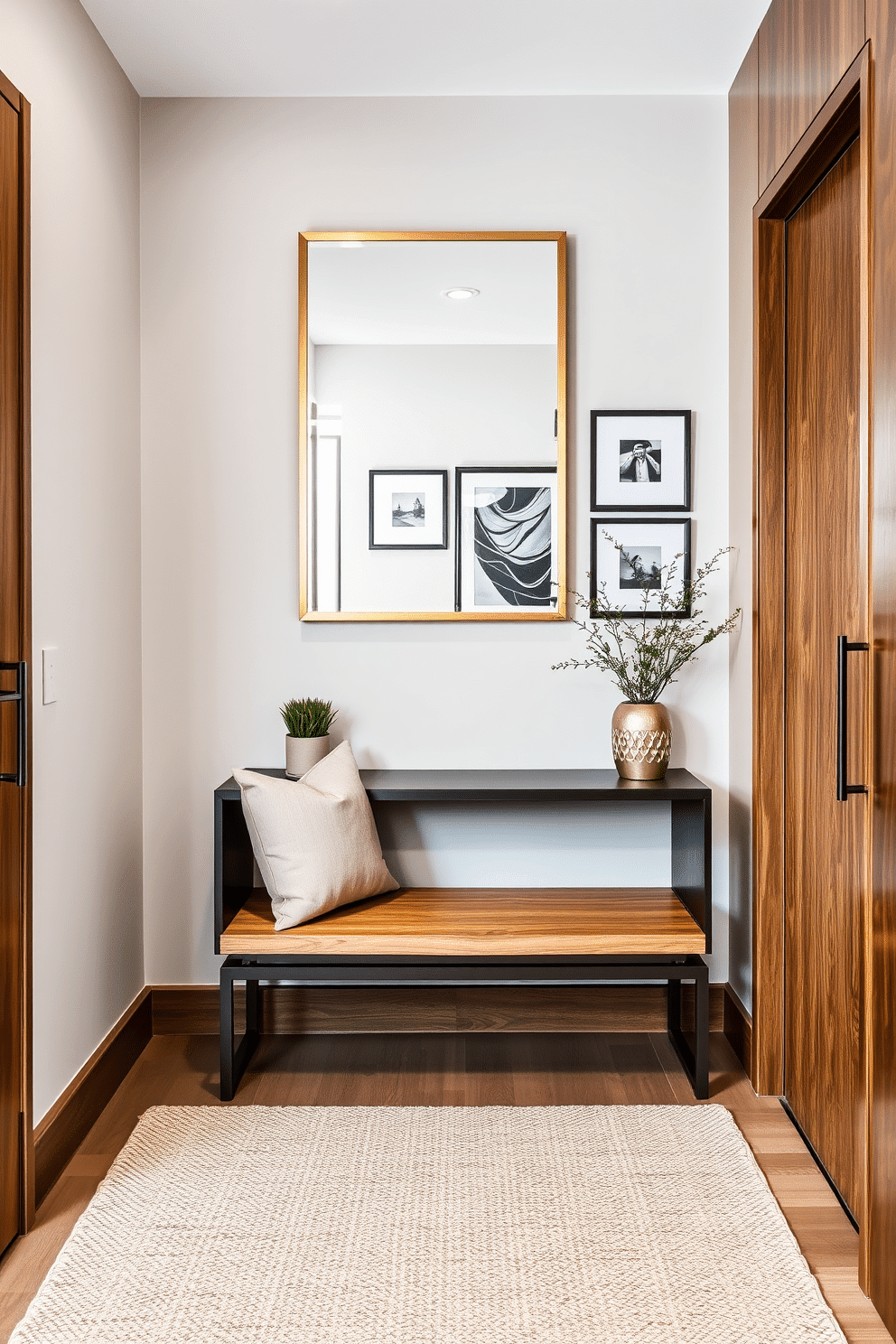 A stylish condo entryway featuring a blend of rich wooden elements and sleek metal accents. The space includes a modern console table with a matte black finish, complemented by a warm oak bench adorned with plush cushions. On the wall, an oversized mirror with a brushed gold frame creates an illusion of depth, while a series of framed art pieces add a personal touch. A woven area rug in neutral tones anchors the space, and a small potted plant introduces a hint of greenery.