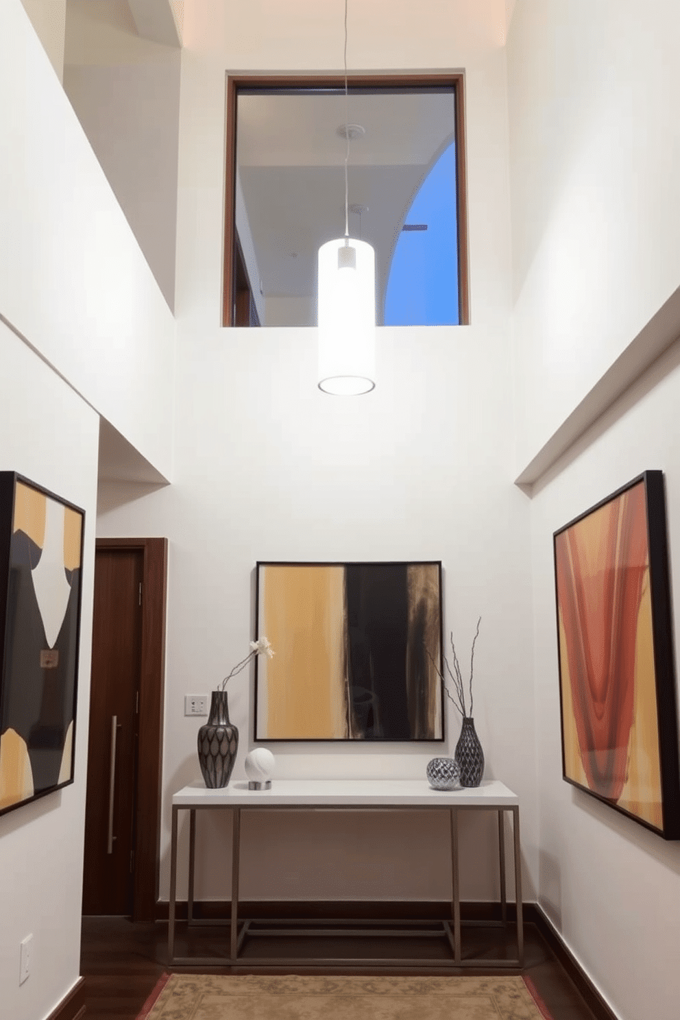 A stylish condo entryway features a bright pendant light hanging from a high ceiling, casting a warm glow that enhances the space's inviting atmosphere. The walls are adorned with modern art, and a sleek console table with decorative accents creates a functional yet aesthetically pleasing focal point.