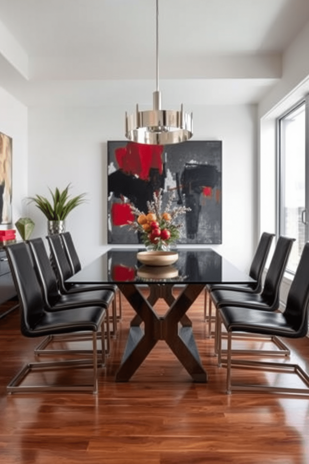 A contemporary dining room features a sleek glass table surrounded by chairs with metal finishes, adding a modern touch to the space. The walls are adorned with abstract art, while a stylish pendant light with metallic accents hangs above the table, creating an inviting atmosphere. The color palette consists of neutral tones complemented by bold accents, enhancing the sophisticated vibe of the room. Large windows allow natural light to flood in, illuminating the polished wood floor and highlighting the elegant design elements throughout.