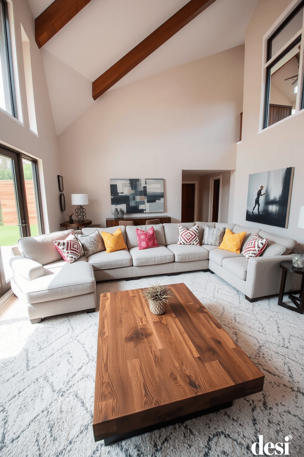 A contemporary family room featuring a large sectional sofa that invites comfort and relaxation. The sofa is upholstered in a soft, light gray fabric, complemented by an array of colorful throw pillows that add a pop of personality. In front of the sofa, a sleek coffee table made of reclaimed wood provides a rustic touch. The walls are adorned with abstract art, and large windows allow natural light to flood the space, enhancing the warm, inviting atmosphere.