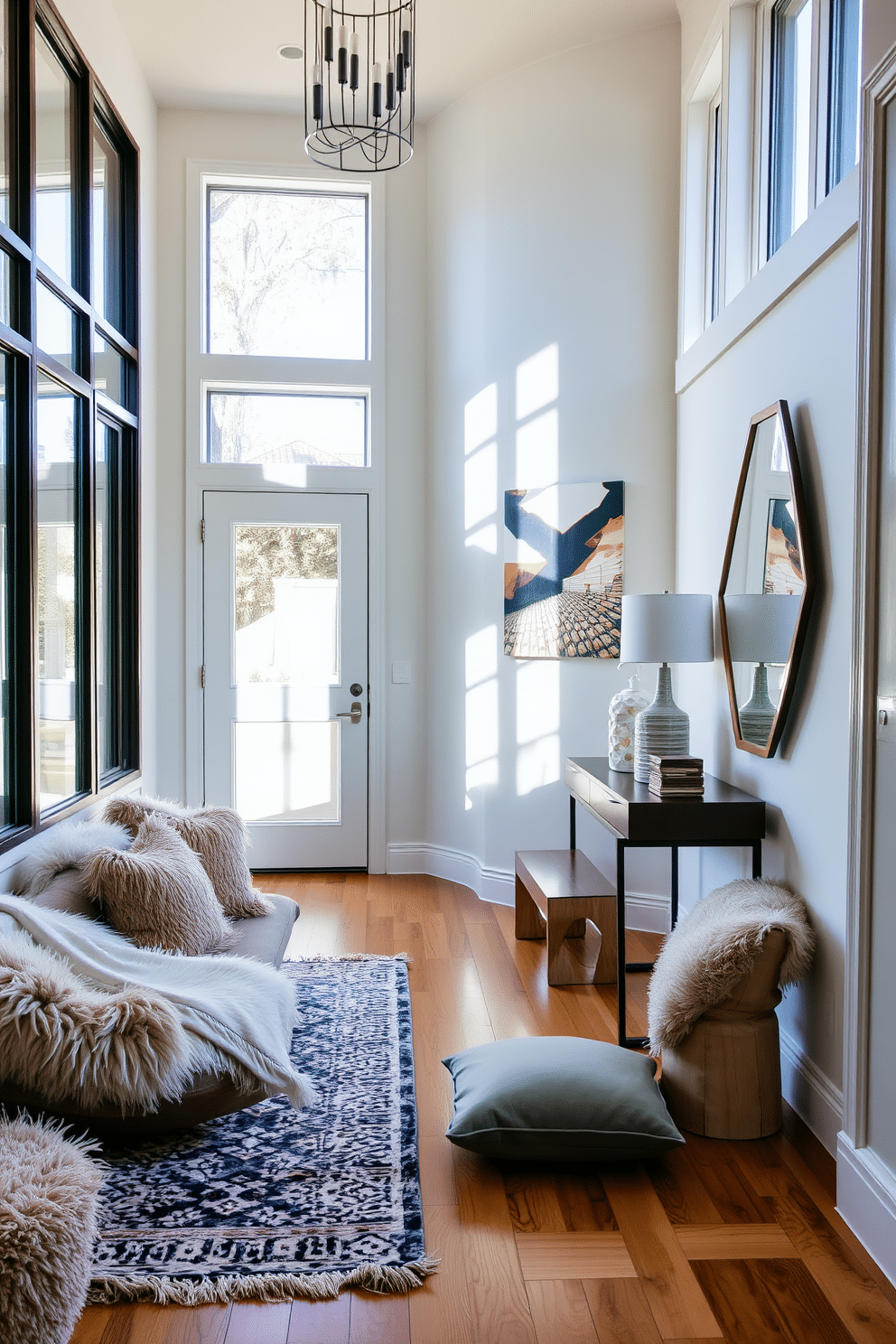 A contemporary foyer featuring layered textures with a mix of plush cushions and soft throws. The space is adorned with a sleek console table, topped with decorative items and a statement mirror, while a stylish rug anchors the area. Bright, natural light floods the foyer through large windows, illuminating the warm wood flooring. A bold artwork piece hangs on the wall, adding a pop of color and personality to the inviting entrance.