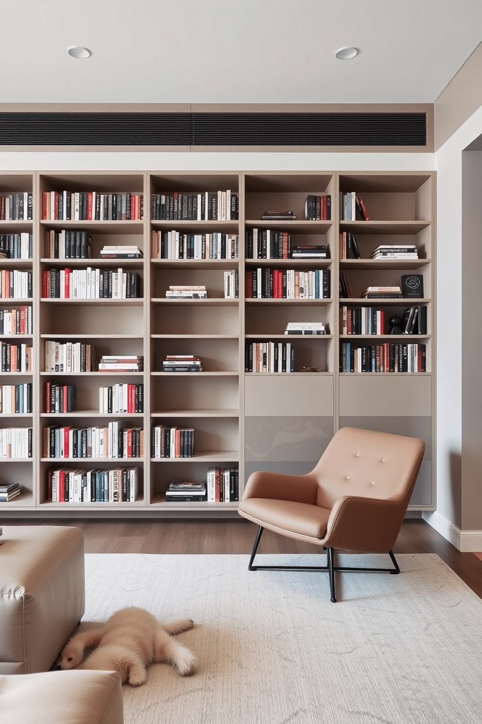 A contemporary home library featuring sleek furniture with clean lines. The space includes a large, minimalist bookshelf filled with books, complemented by a comfortable reading chair in a muted color palette.