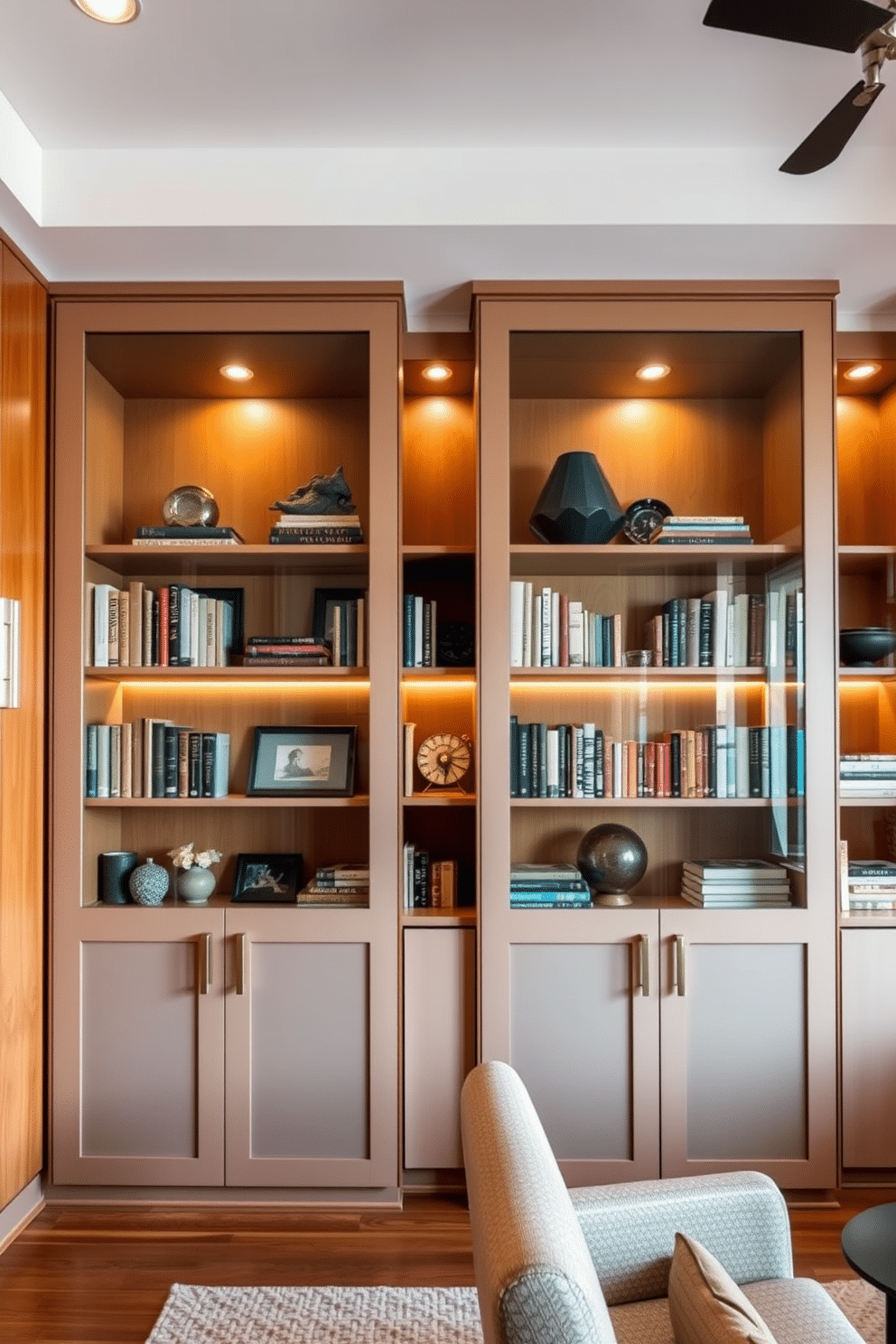 A contemporary home library features sleek glass doors on elegant bookcases that showcase a curated collection of books and decorative items. The space is accented with warm wood tones and modern lighting fixtures, creating a cozy yet sophisticated atmosphere.