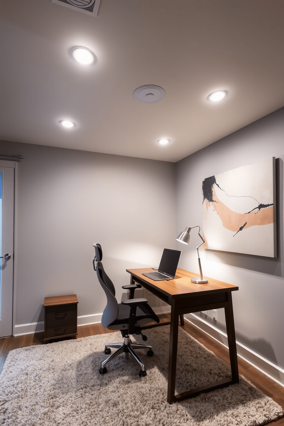 A contemporary home office featuring layered lighting for both ambiance and function. Recessed ceiling lights provide general illumination, while a stylish desk lamp offers focused task lighting on a sleek wooden desk. The walls are painted in a soft gray, complemented by a large abstract art piece that adds a pop of color. A comfortable ergonomic chair sits at the desk, and a plush area rug defines the workspace, enhancing the cozy atmosphere.