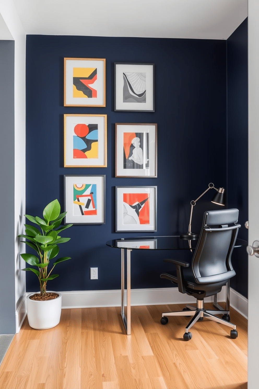 A bold accent wall painted in deep navy blue serves as a striking backdrop for a curated display of modern artwork, featuring abstract pieces in vibrant colors. The adjacent workspace includes a sleek, minimalist desk with a glass top and a comfortable ergonomic chair, complemented by stylish task lighting. Incorporating natural elements, a potted plant sits in the corner, adding a touch of greenery to the contemporary aesthetic. The flooring is a light oak, enhancing the overall brightness of the room while providing a warm contrast to the bold wall.