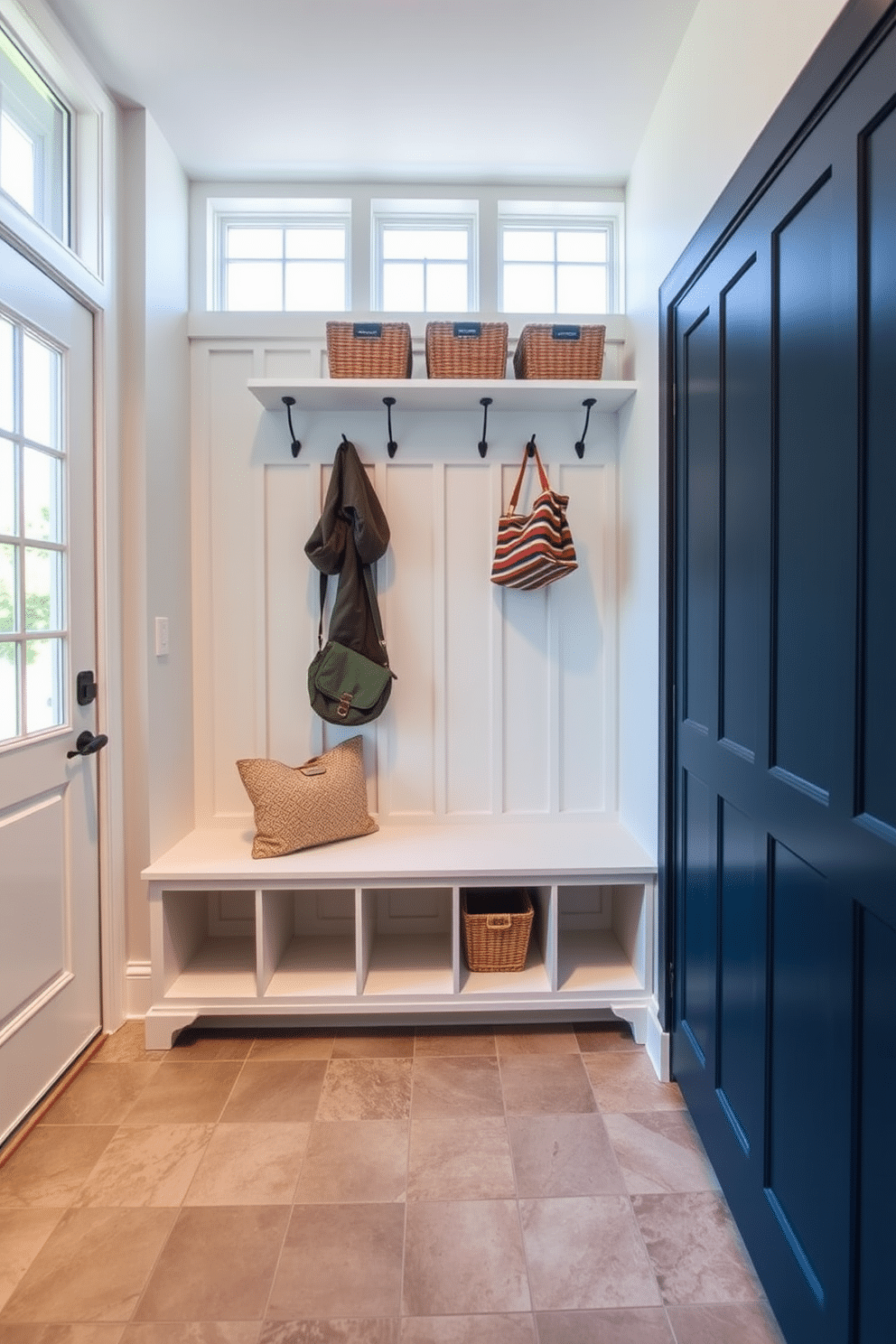 A functional drop zone for daily essentials features a sleek built-in bench with storage cubbies underneath. Above the bench, hooks are mounted on a wall for coats and bags, while a small shelf holds decorative baskets for organization. In a contemporary mudroom design, the space is brightened by large windows that let in natural light. The flooring is durable and stylish, combining ceramic tiles with a warm wood accent to create a welcoming atmosphere.