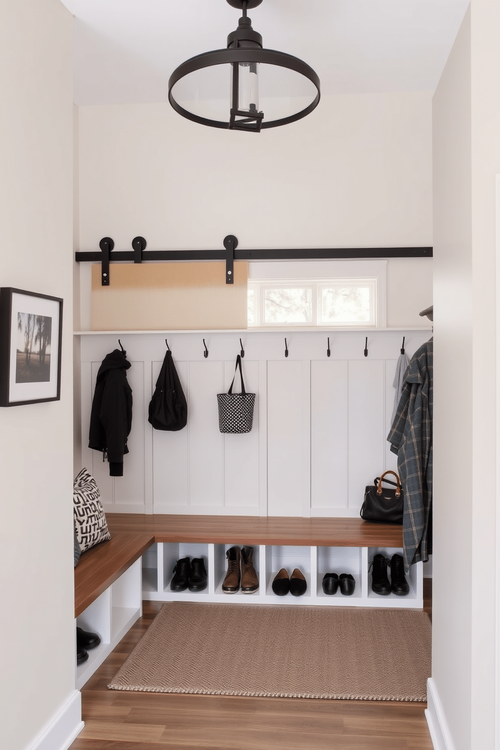 A contemporary mudroom features a sliding barn door that seamlessly blends with the surrounding decor, providing a space-saving solution for entry. Inside, custom-built storage benches and hooks line the walls, creating an organized and inviting area for shoes and outerwear.