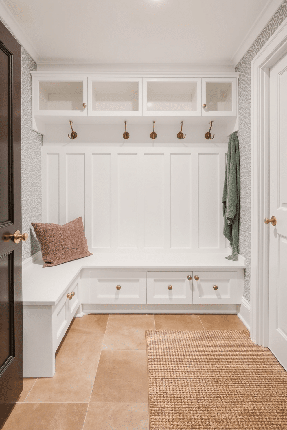 A durable flooring solution for high traffic areas features large-format porcelain tiles in a warm taupe color, ensuring both style and resilience. The flooring is complemented by a textured area rug that adds warmth and comfort while maintaining easy maintenance. For a contemporary mudroom design, envision a sleek built-in bench with storage cubbies above and below, finished in a crisp white. The walls are adorned with a geometric patterned wallpaper, and a row of hooks in brushed nickel provides a functional yet stylish touch.