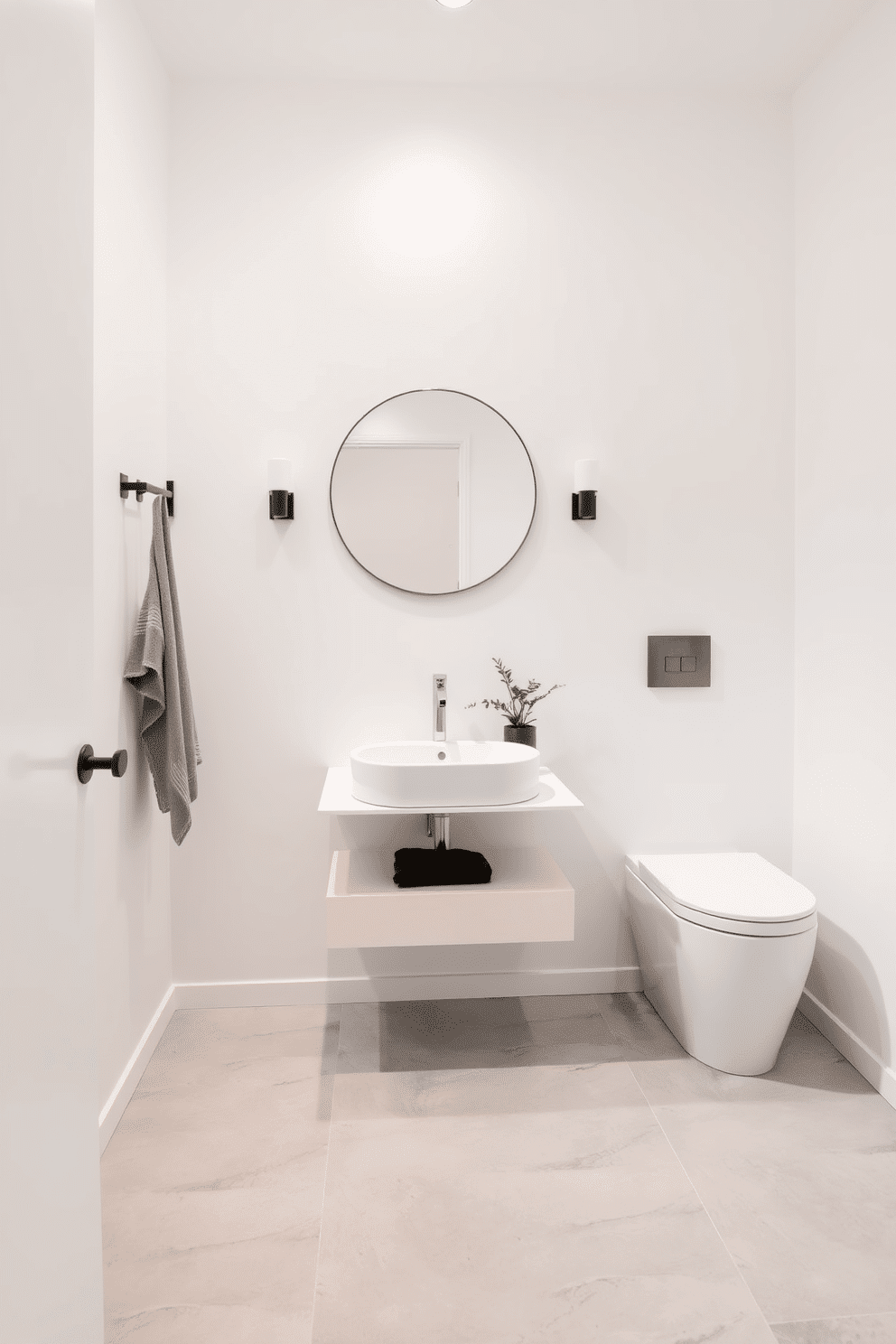 A contemporary powder room featuring minimalist fixtures that emphasize a clean and uncluttered aesthetic. The walls are painted in a soft white, complemented by a sleek floating vanity with a single, elegant sink and a simple, round mirror above it. The space is adorned with subtle accents, such as a small potted plant on the vanity and a monochromatic color palette throughout. The flooring consists of large, light gray tiles, enhancing the room's airy feel while maintaining a sophisticated charm.