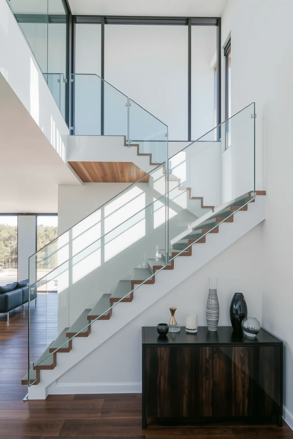 Open-concept staircase featuring sleek, transparent glass panels that create a seamless flow between levels. The staircase is framed by a minimalist metal railing, enhancing the modern aesthetic while allowing natural light to illuminate the space. The treads are crafted from rich, dark wood, providing a striking contrast to the light-colored walls surrounding the staircase. Below, a stylish console table adorned with decorative items complements the overall contemporary design.