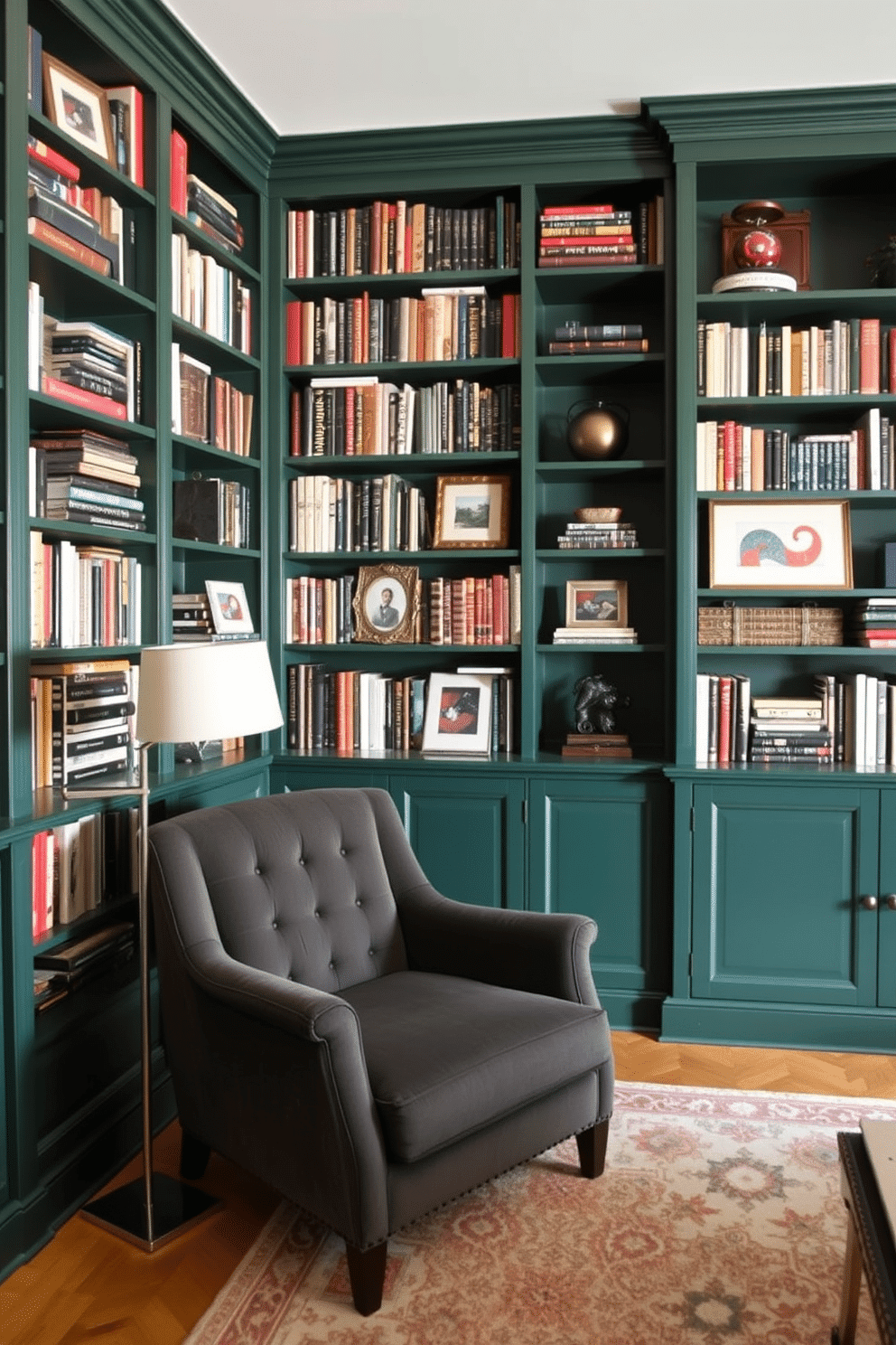 A cozy home library featuring floor-to-ceiling bookshelves in a rich dark green hue. The shelves are filled with an eclectic mix of books, framed photographs, and decorative objects that add personality to the space. A plush, deep-seated armchair in a complementary shade sits invitingly in one corner, paired with a sleek, modern reading lamp. A soft, patterned area rug anchors the seating area, while warm, ambient lighting creates a welcoming atmosphere for reading and relaxation.