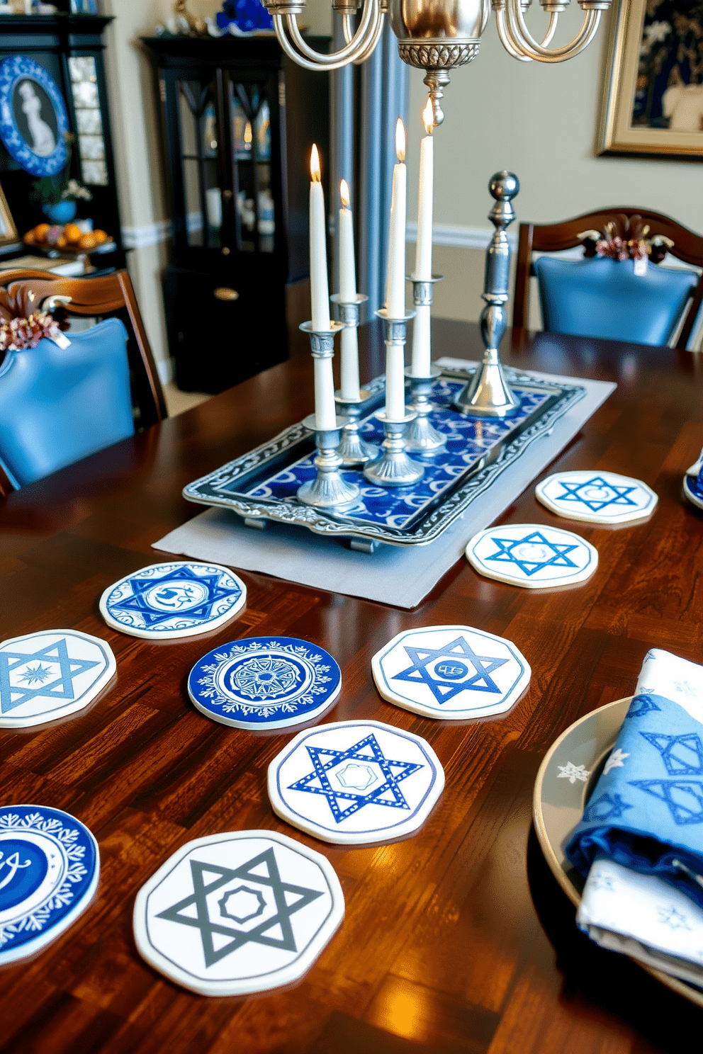 Themed coasters featuring intricate designs inspired by traditional Hanukkah symbols, such as the menorah and dreidel, are scattered across the dining table. Each coaster is crafted from high-quality ceramic with a glossy finish, adding a touch of elegance and festive spirit to the dining experience. The dining room is adorned with beautiful blue and silver decorations, including a stunning centerpiece of silver-colored candles arranged on a decorative tray. Festive tableware complements the theme, with plates and napkins featuring subtle Star of David patterns, creating a warm and inviting atmosphere for family gatherings during Hanukkah.