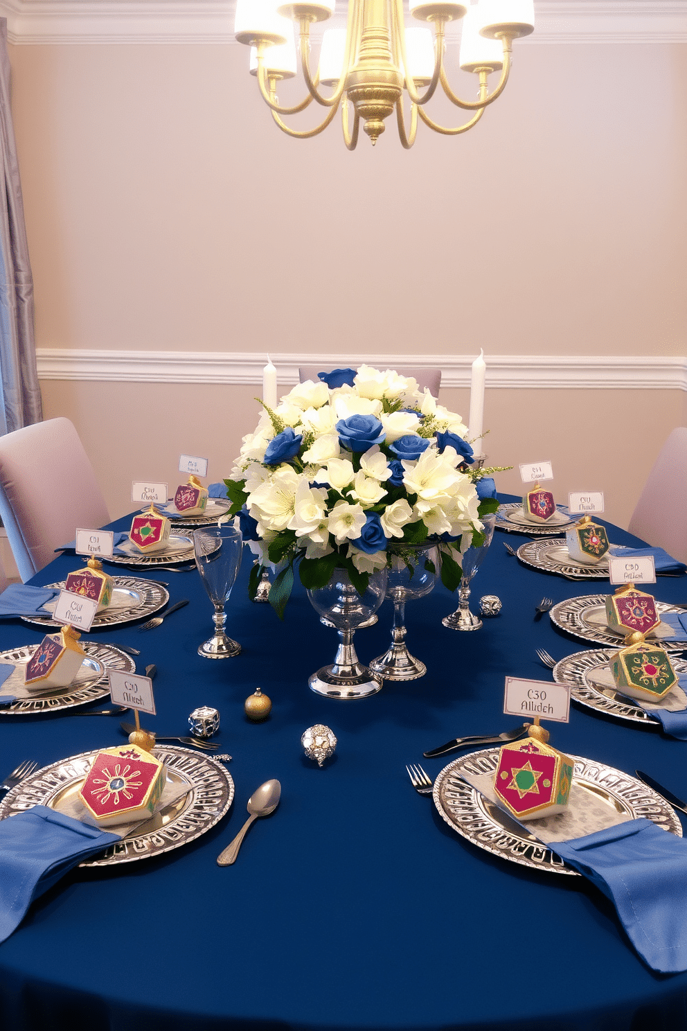 A festive dining room setting for Hanukkah features elegant dreidel-themed place card holders crafted from ceramic, each adorned with vibrant colors and intricate designs. The table is set with a rich blue tablecloth, complemented by silver and gold accents, including sparkling menorahs and decorative dreidels scattered across the center. The dining chairs are upholstered in a soft fabric that matches the tablecloth, creating a cohesive look. Soft, warm lighting from overhead fixtures enhances the inviting atmosphere, while a beautiful floral arrangement in shades of white and blue sits at the center, adding a touch of elegance.