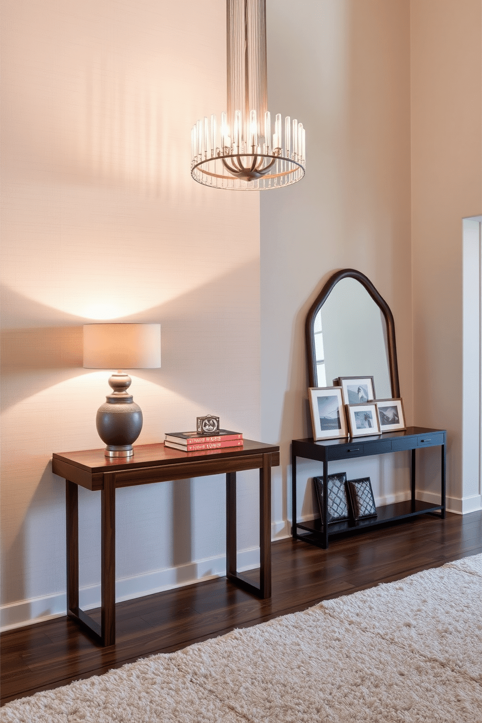 A sleek, elegant side table made of polished walnut stands against a soft, textured wall. Adorning the table are carefully curated decorative displays, including a sculptural vase and a stack of art books, complemented by a warm table lamp that casts a gentle glow. The entrance foyer features a grand chandelier hanging from a high ceiling, illuminating the space with a soft, inviting light. A stylish console table against the wall showcases a large mirror and a collection of framed artwork, while a plush area rug adds warmth underfoot.