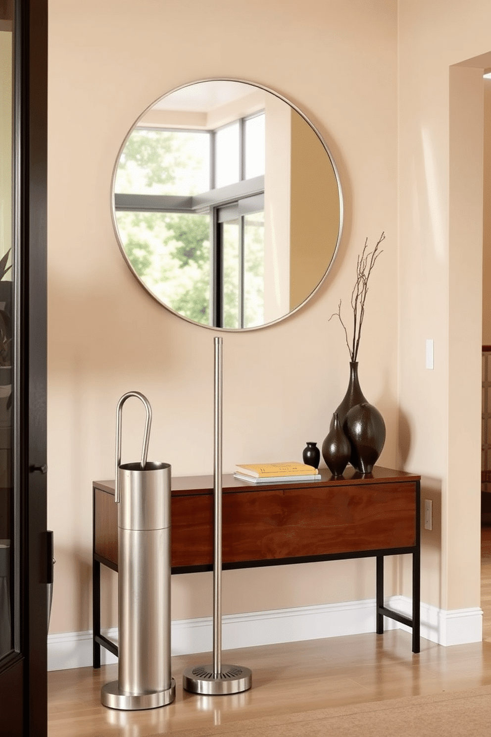 A stylish umbrella stand designed for rainy days features a sleek, modern silhouette crafted from brushed stainless steel. It stands elegantly in the entryway, complemented by a minimalist design that incorporates a subtle drainage system at the base. The entryway is adorned with a warm, inviting color palette, showcasing a combination of soft beige walls and a rich wooden console table. Above the table, a large round mirror reflects natural light, enhancing the space's openness and functionality.