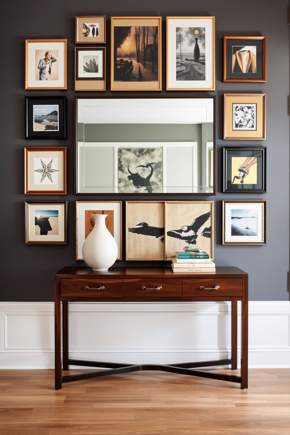 A stunning entryway table is adorned with layered artwork that creates a captivating focal point. The wall behind features a mix of framed prints and canvases in various sizes, showcasing an eclectic color palette that complements the table's finish. The table itself is a sleek, modern design with a rich wood stain, topped with decorative items like a sculptural vase and a stack of stylish books. A large mirror above the table reflects light and adds depth, enhancing the overall ambiance of the entryway.