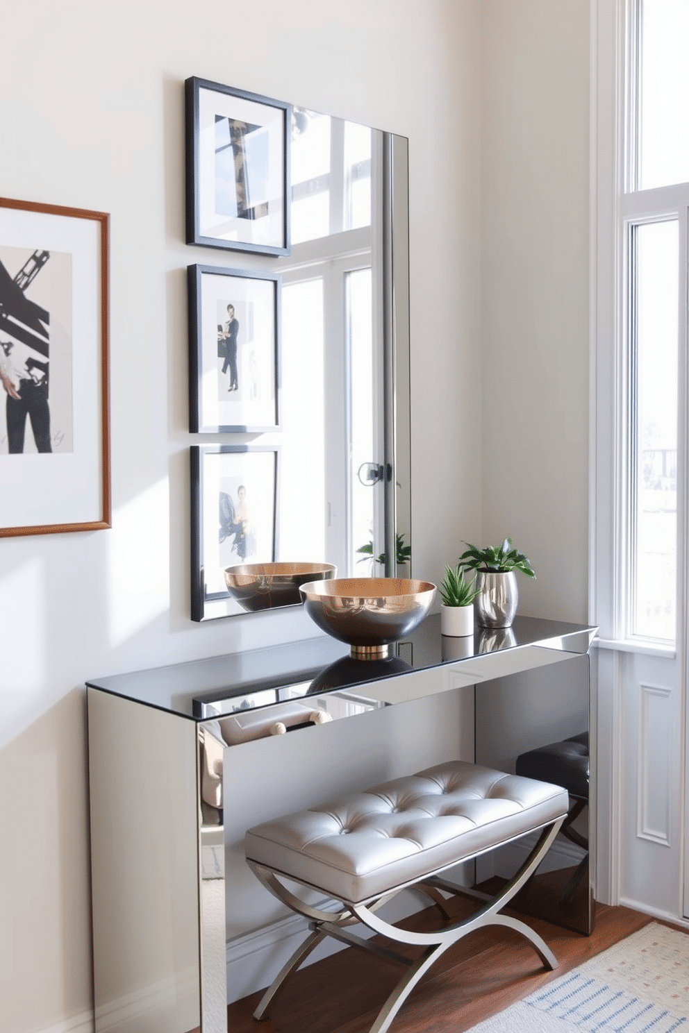 A stylish entryway featuring mirrored furniture that reflects natural light, creating a sense of spaciousness. The focal point is a sleek mirrored console table adorned with a decorative bowl and a small potted plant, enhancing the airy feel of the space. The walls are painted in a soft, neutral tone, complemented by a gallery of framed artwork that adds personality. A chic bench with a mirrored finish sits below a statement mirror, providing both functionality and elegance to the entryway design.