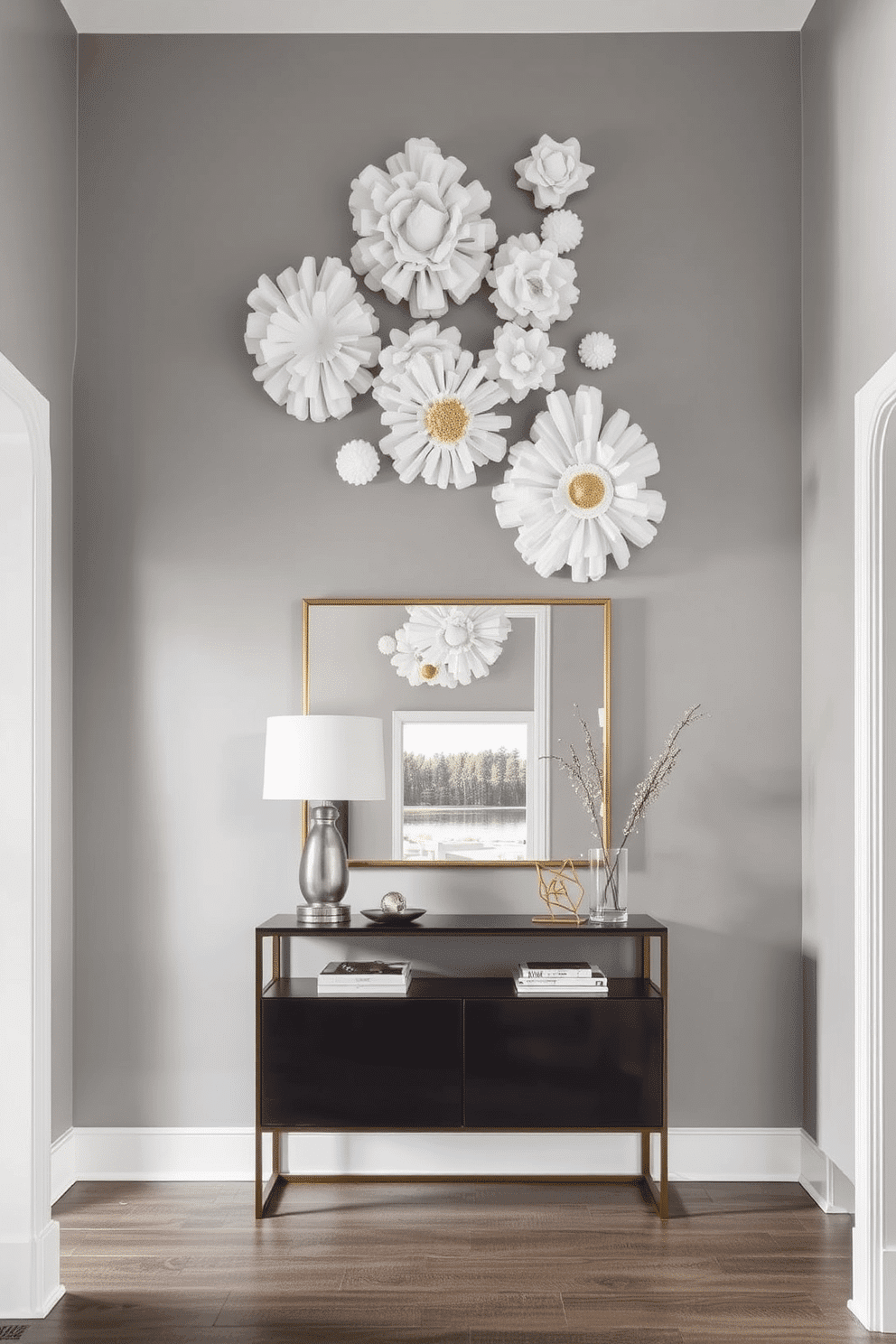 A striking entryway features sculptural wall hangings that create a dynamic focal point. The walls are painted a soft gray, allowing the textured pieces in white and gold to stand out beautifully. To enhance the design, a sleek console table sits below the artwork, adorned with a stylish lamp and a few curated decor items. A large mirror above the table reflects light and adds depth to the space, making the entryway feel more inviting.