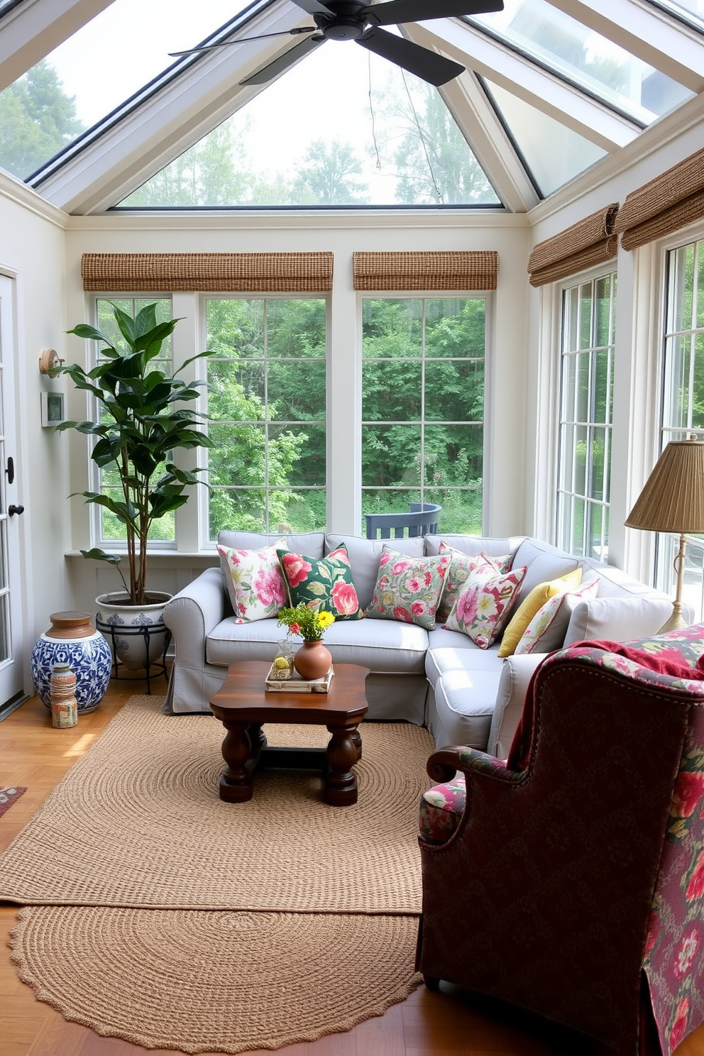 A cozy sunroom adorned with a blend of textures and patterns. The walls are painted in a soft cream color, and large windows allow natural light to flood the space. A plush, light gray sectional sofa is covered with an array of colorful throw pillows featuring floral and geometric designs. A woven jute rug anchors the seating area, while a rustic wooden coffee table adds warmth. In one corner, a tall indoor plant adds a touch of greenery, complemented by a patterned ceramic planter. On the opposite side, a vintage armchair upholstered in a bold fabric provides an inviting reading nook.