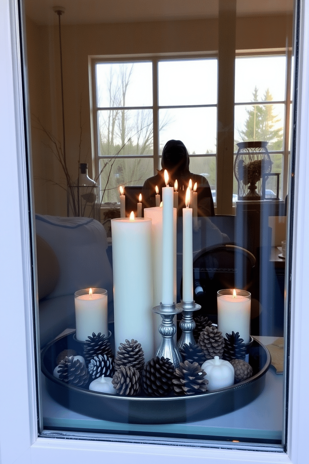 A cozy fall window display featuring decorative trays arranged with an assortment of candles in varying heights. Nestled among the candles are natural pinecones, adding a rustic touch to the seasonal decor.